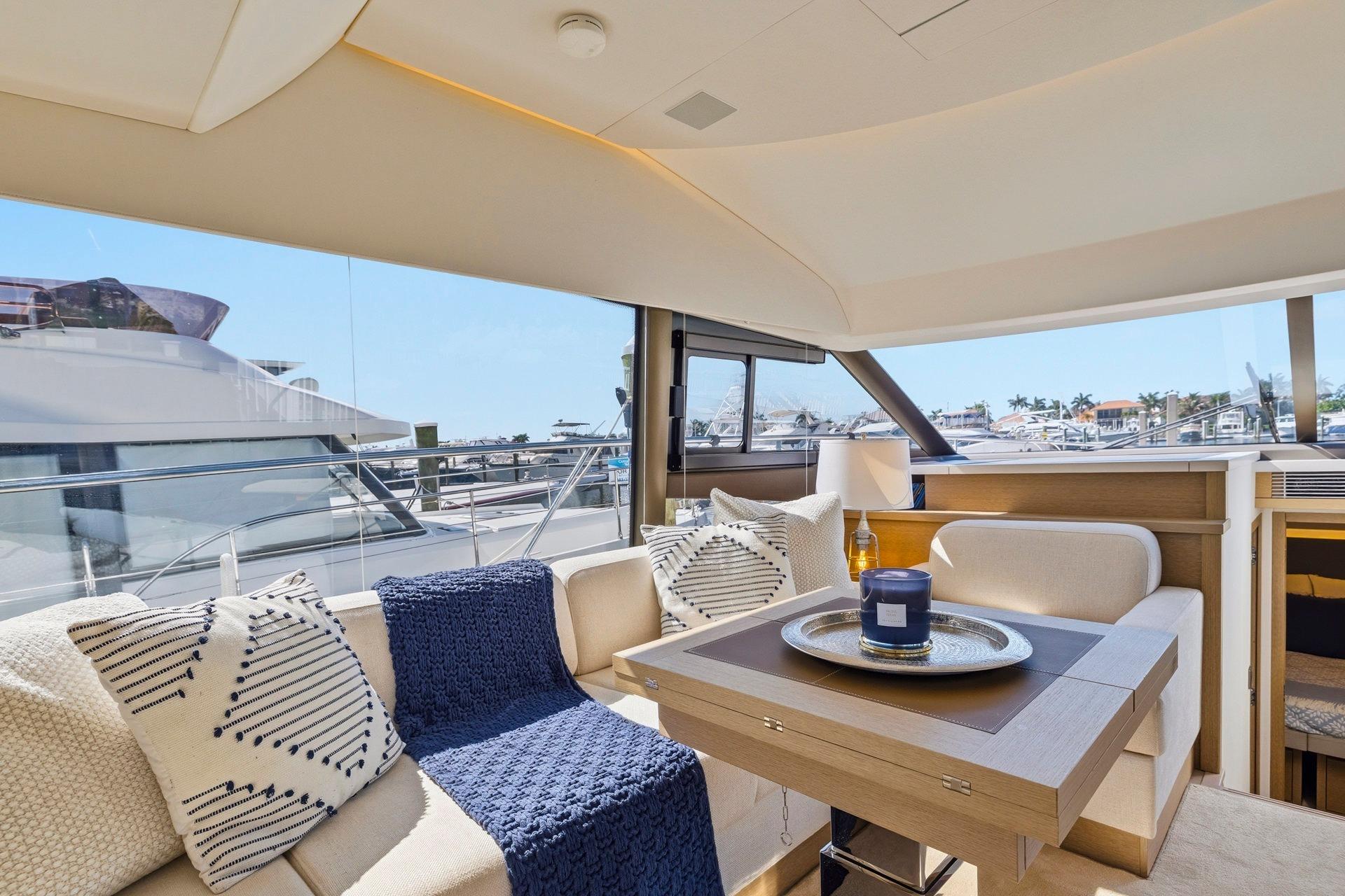 Luxurious interior of 2022 Prestige 520 yacht with elegant seating and panoramic windows.