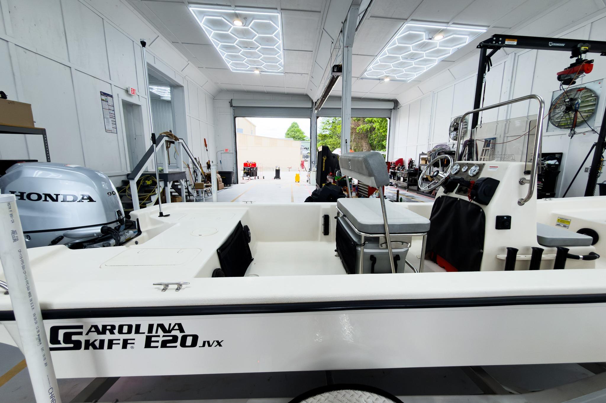 2026 Carolina Skiff E20 JVX CC boat in a workshop with Honda engine.
