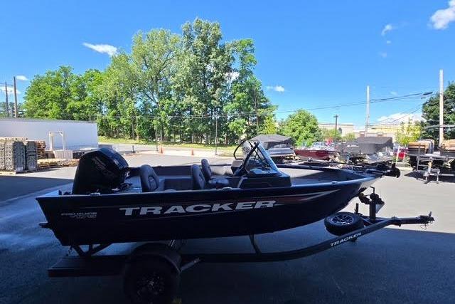 2026 Tracker Pro Guide V-175 WT boat on trailer, parked outdoors under clear blue sky.