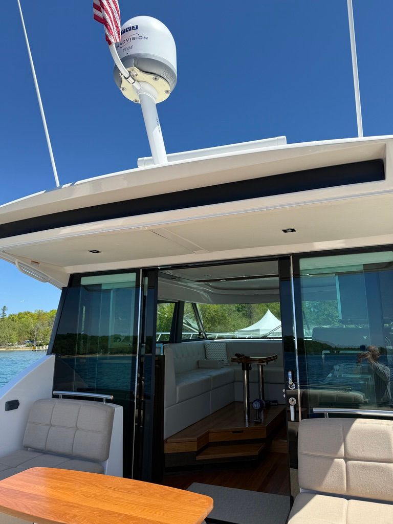2017 Tiara Yachts C44 Coupe with open cockpit and seating area, surrounded by water and trees.