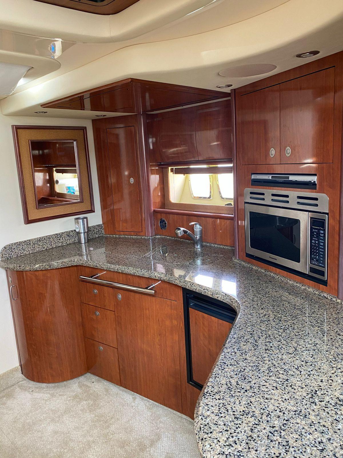 2006 Sea Ray 440 Sundancer yacht kitchen with granite countertops and modern appliances.