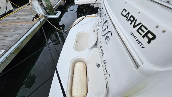 2000 Carver 450 Voyager Pilothouse docked, showcasing rear deck and branding.