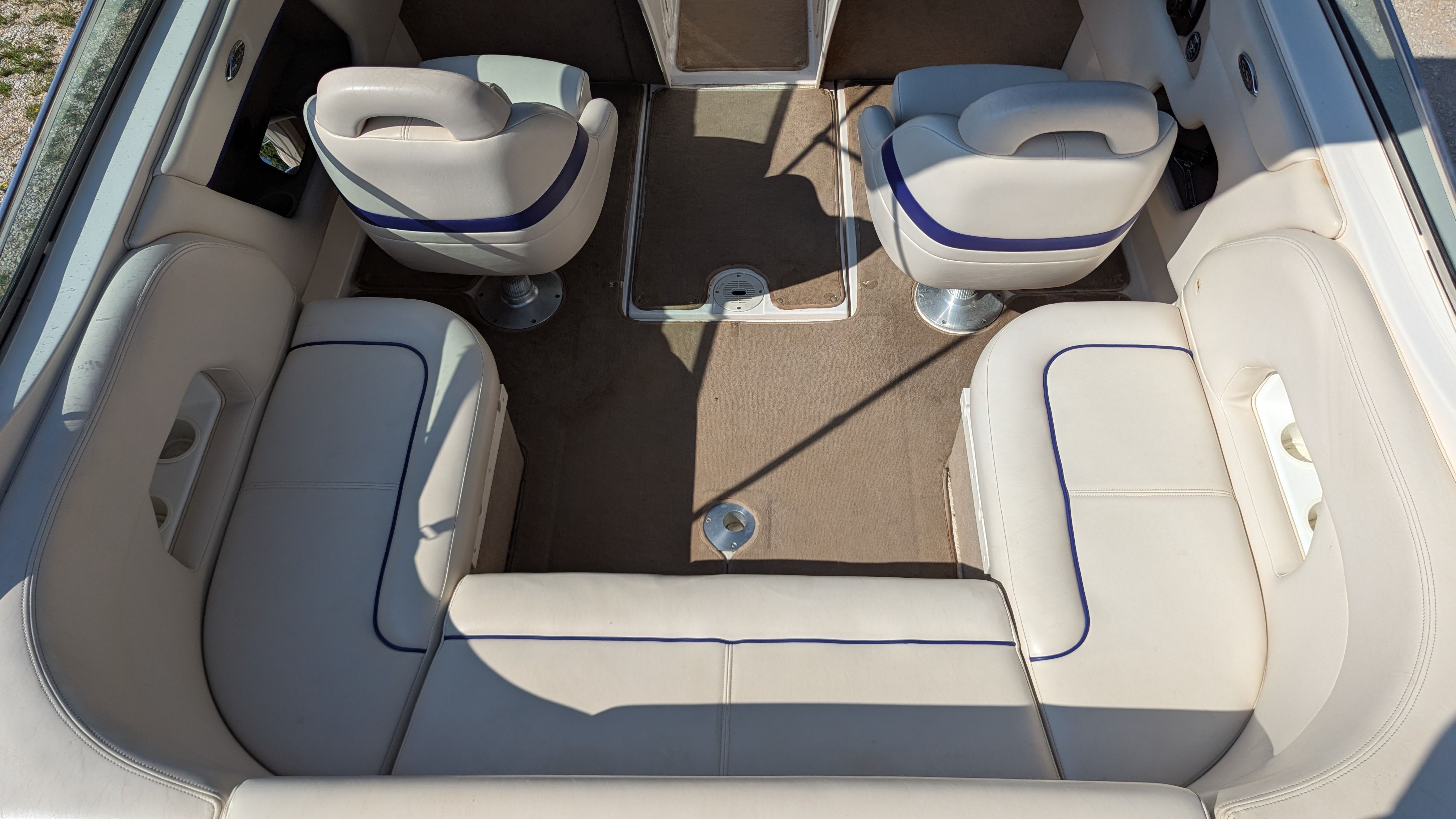 Interior of a 2000 Chaparral 240 SSi with beige seating and carpeted floor.