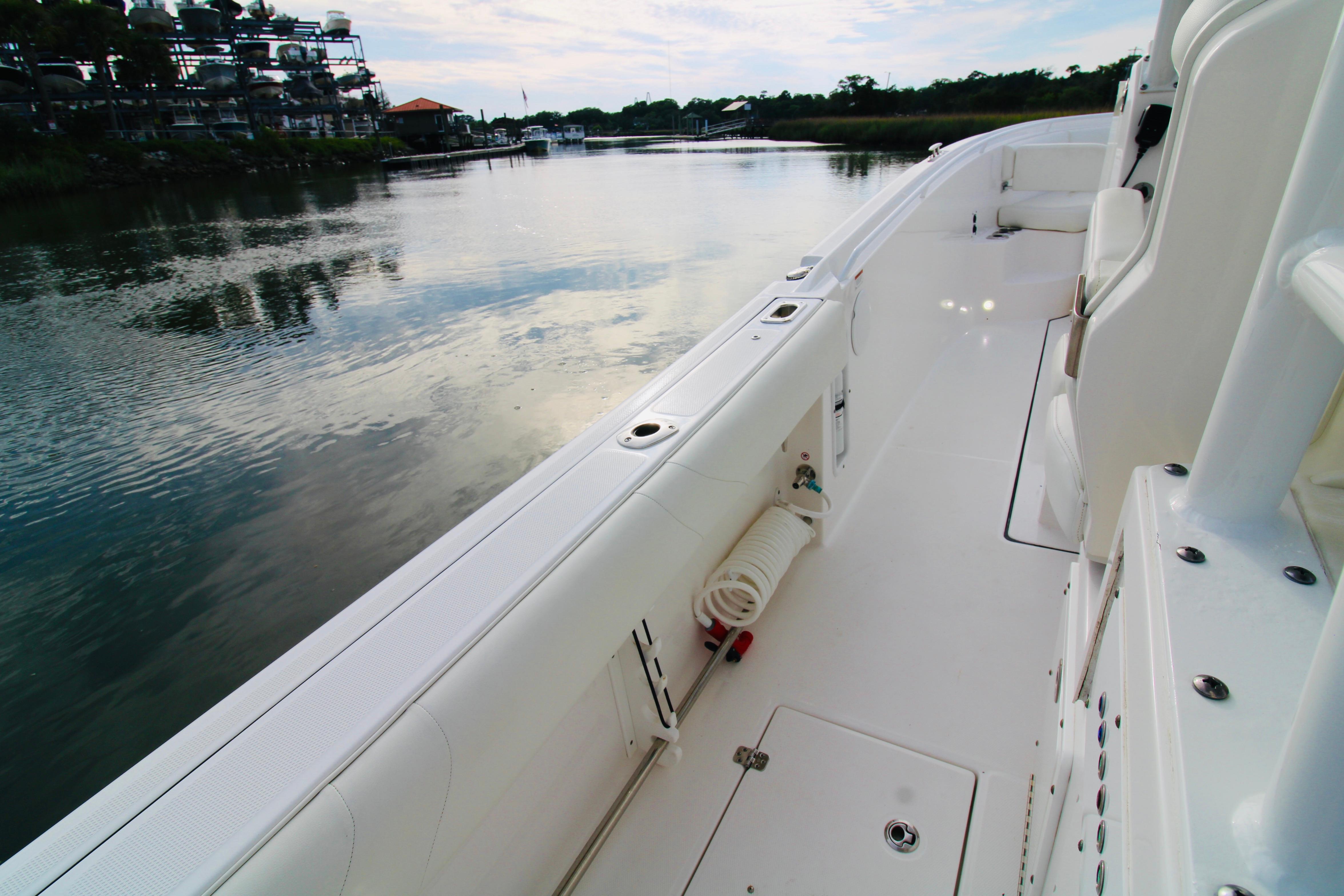 2022 Edgewater 280CC boat interior, featuring sleek white deck and seating by calm waters.