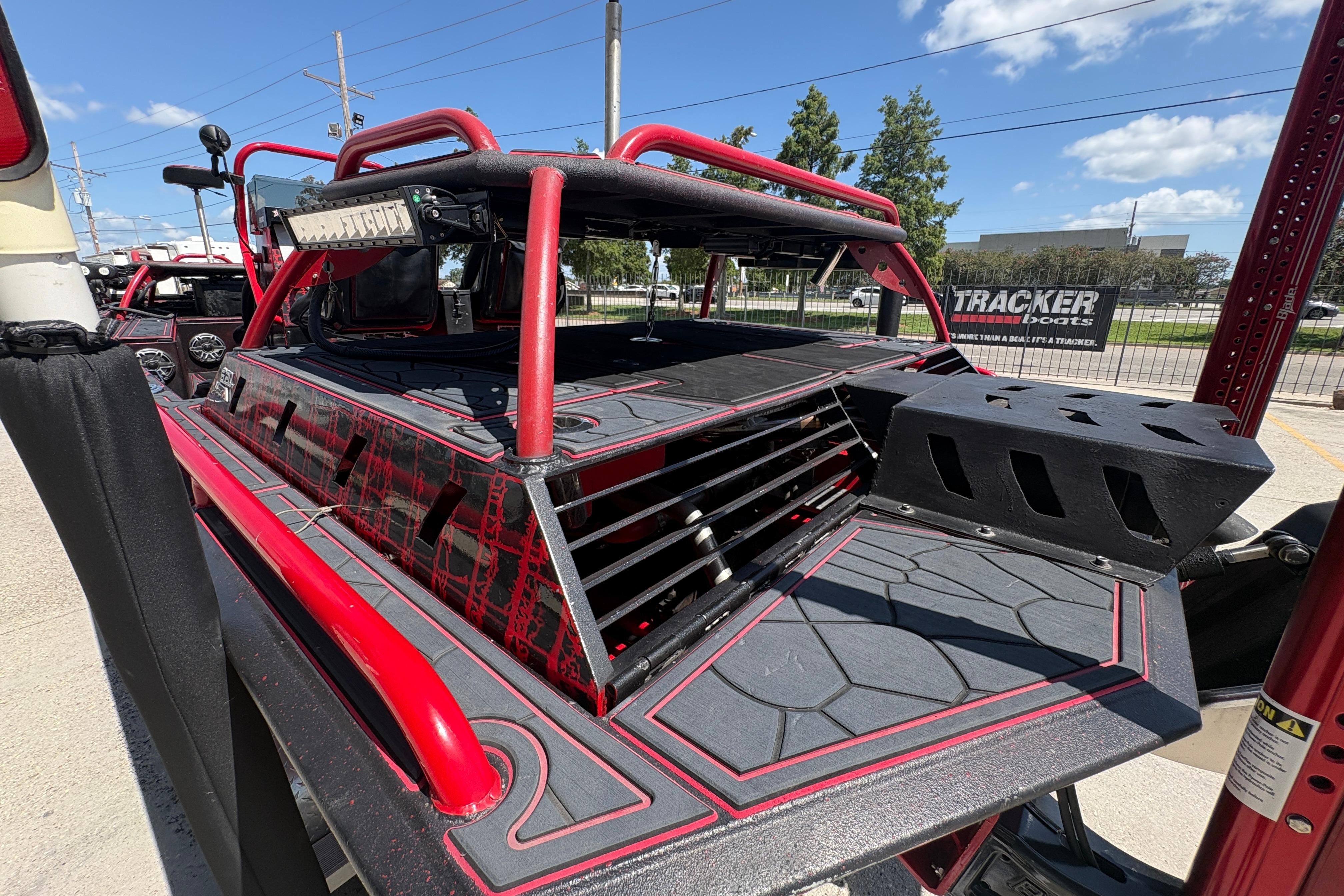 Custom 2018 Swamp Shark 24' boat with red accents and rugged design, parked outdoors.