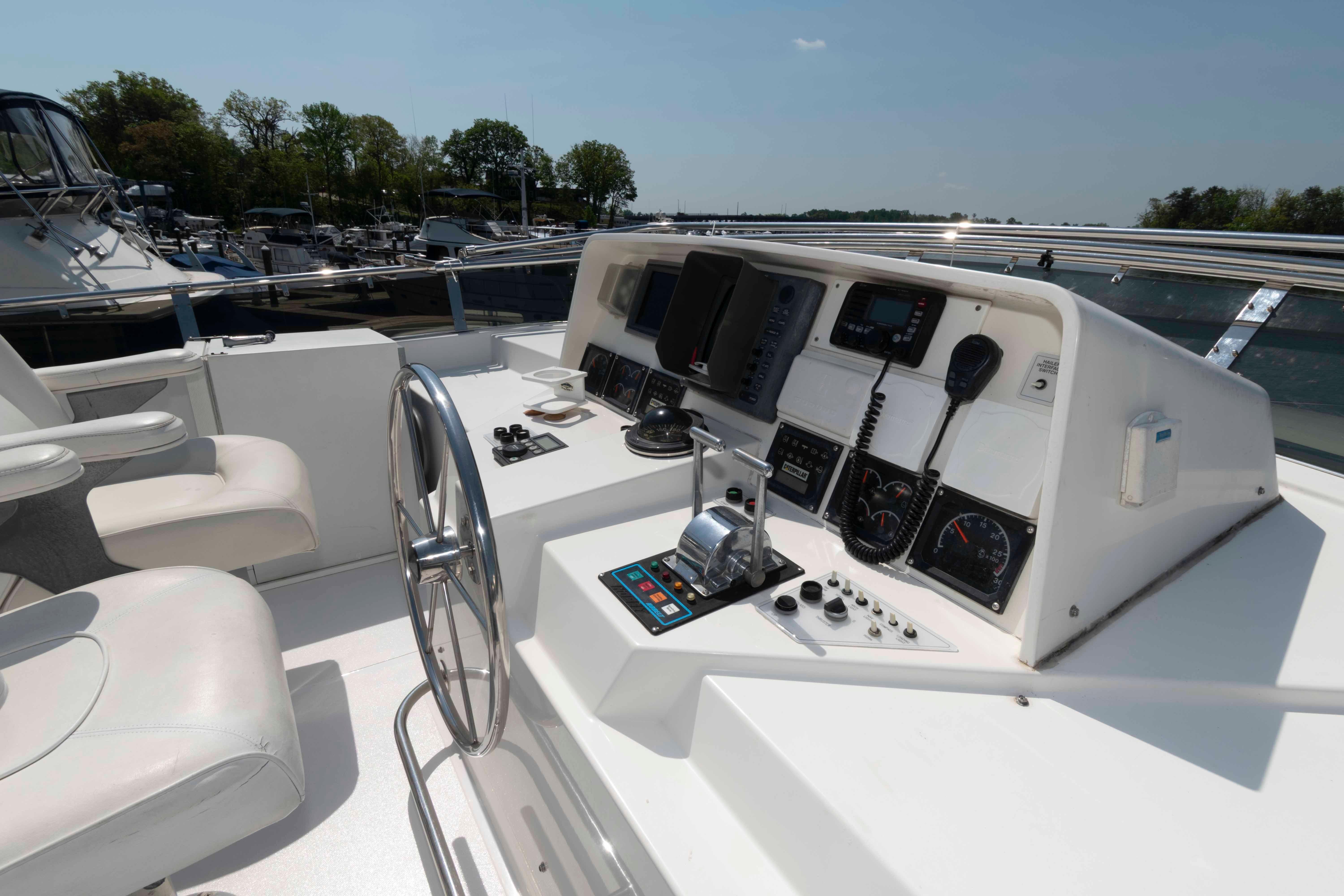 Cockpit of 1999 West Bay 58 Sonship Pilothouse MY with steering wheel and navigation controls.