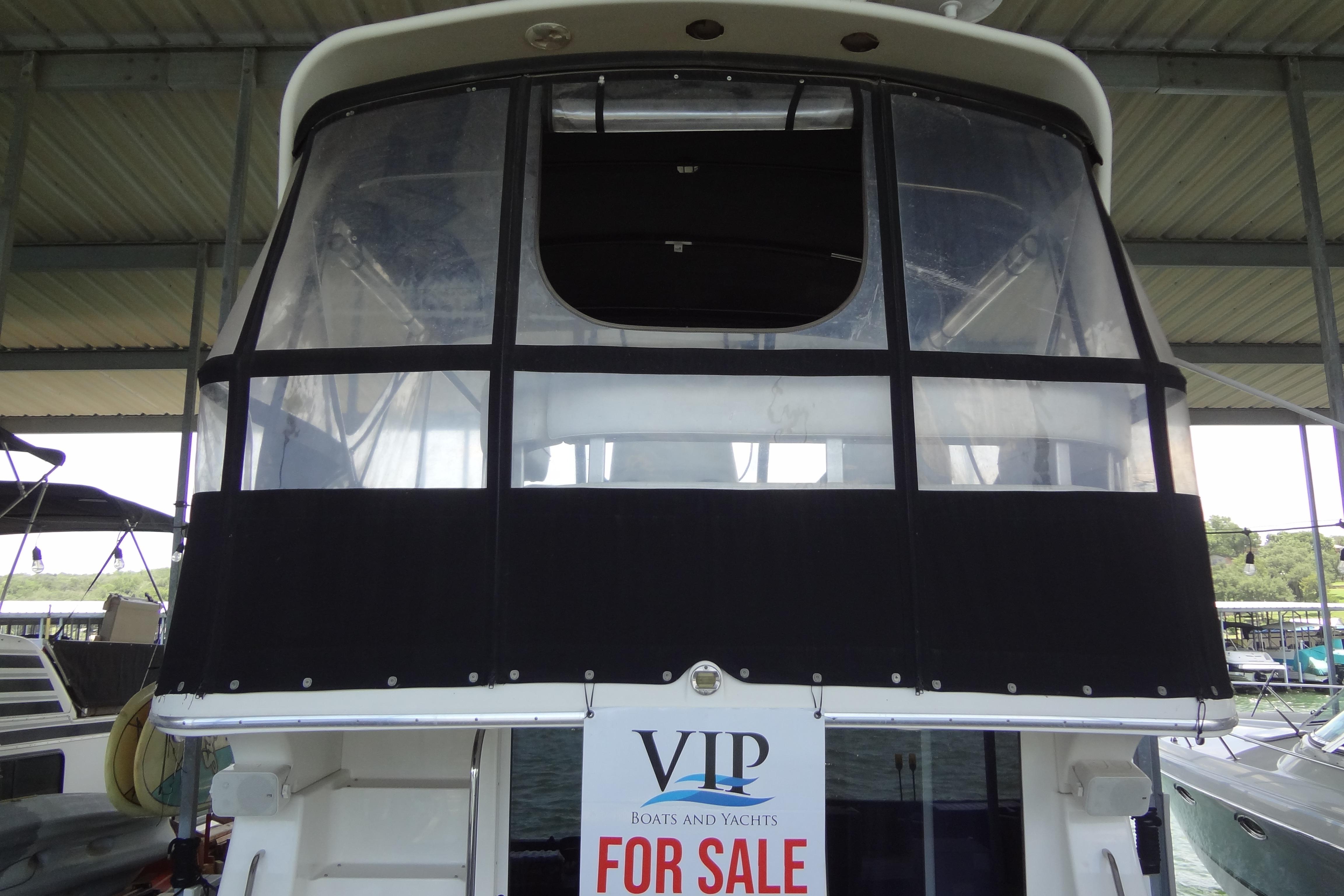 2005 Silverton 34 Convertible yacht for sale, docked under a covered marina.