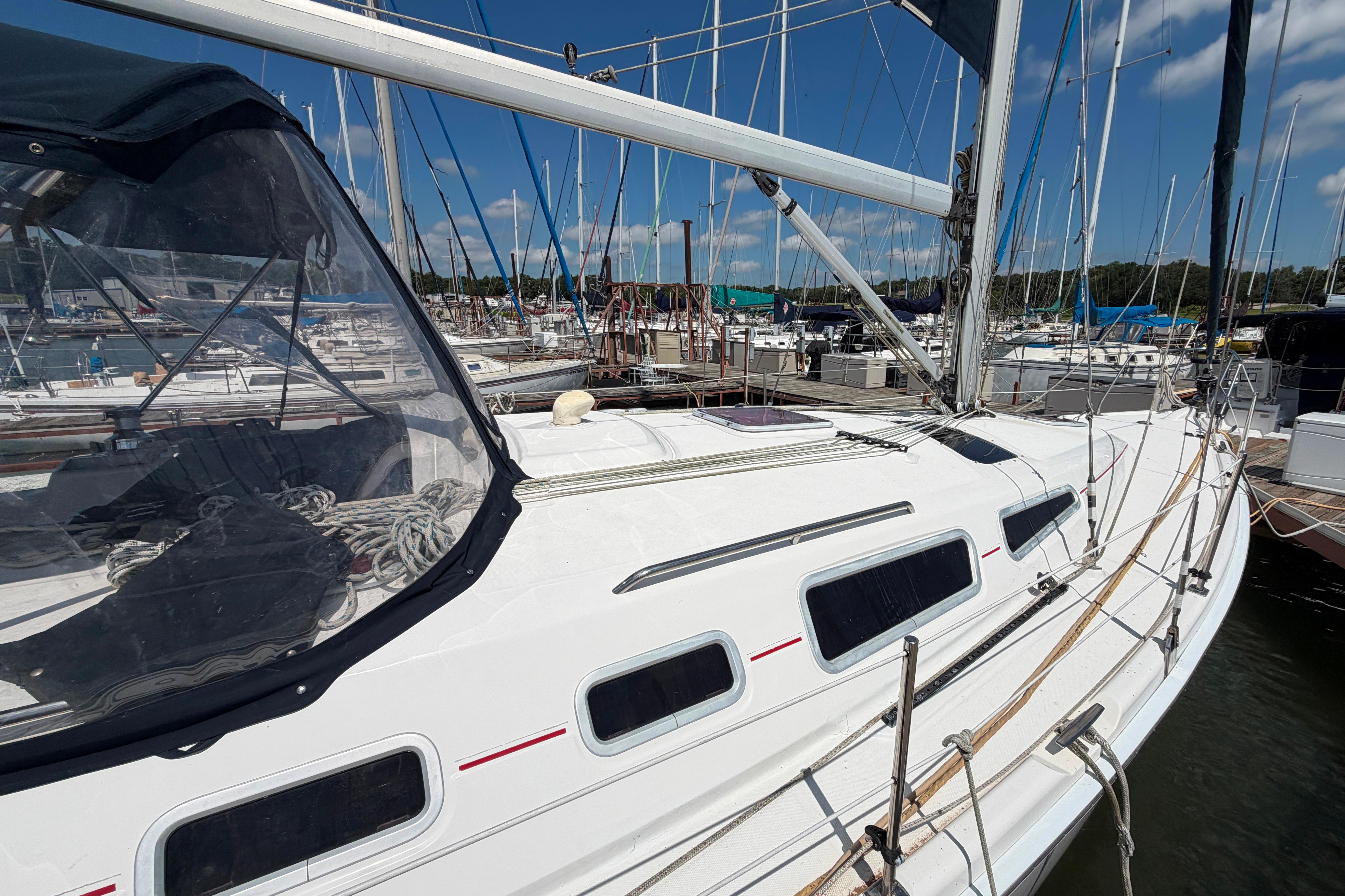 Sailboat docked at marina, Hunter 38 model, 2005, with clear skies and surrounding boats.