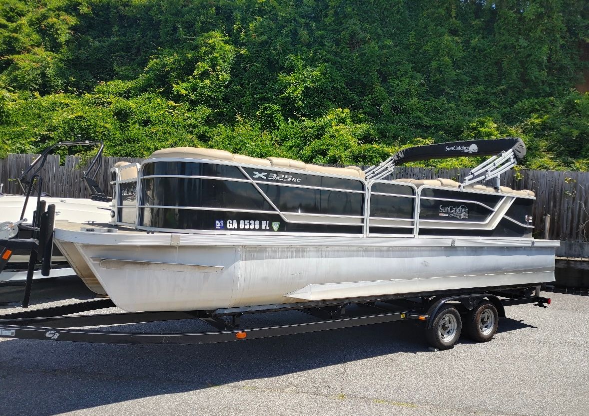 2018 SunCatcher x325 rc pontoon boat on trailer, parked outdoors.