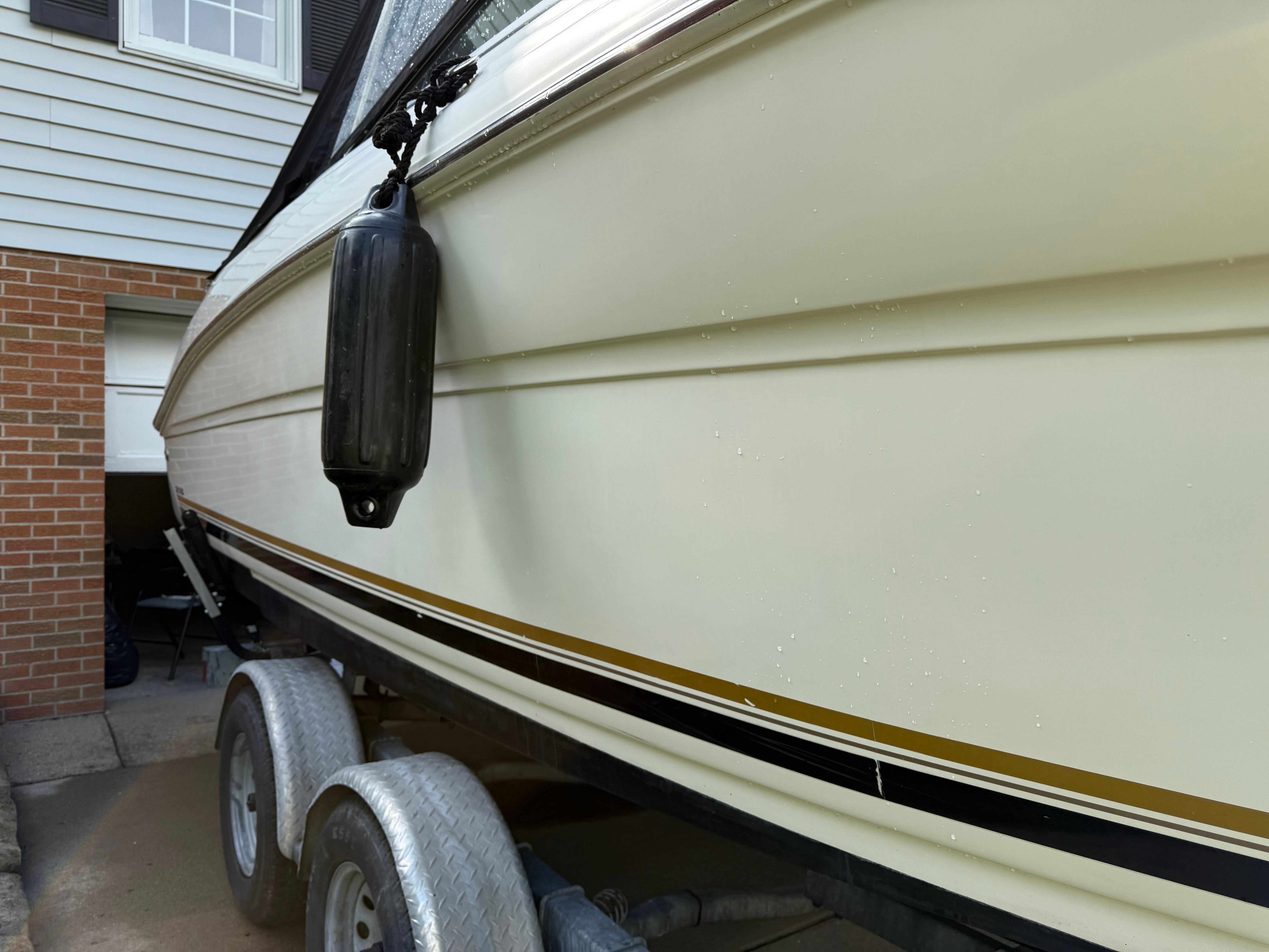 Sea Ray 215 Weekender 2006 on trailer near garage.