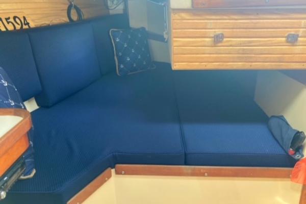 Interior of a 1989 Catalina 30 sailboat with blue cushioned seating.