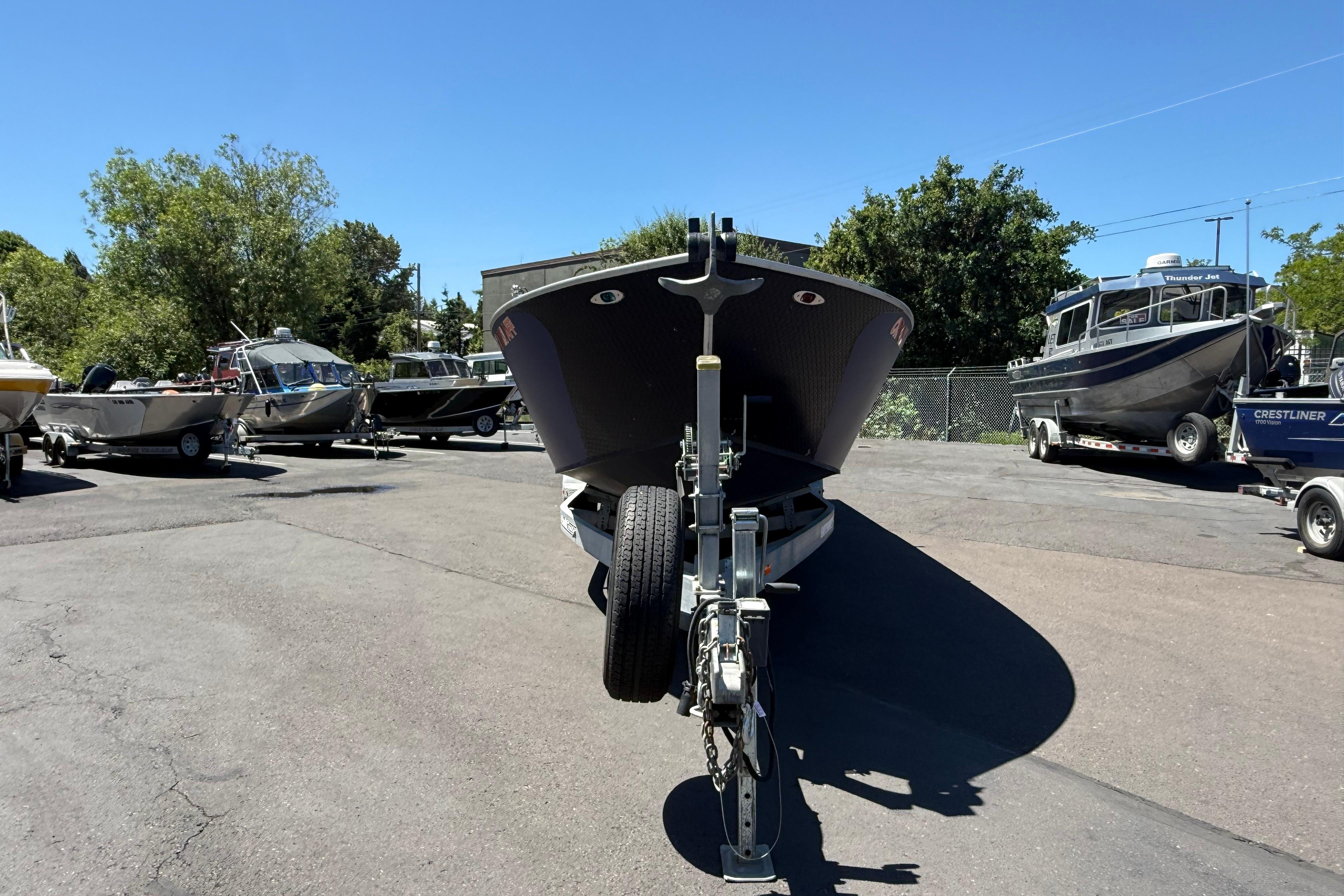 2015 Alumaweld Pacific XD 28 boat on trailer in a sunny parking lot.