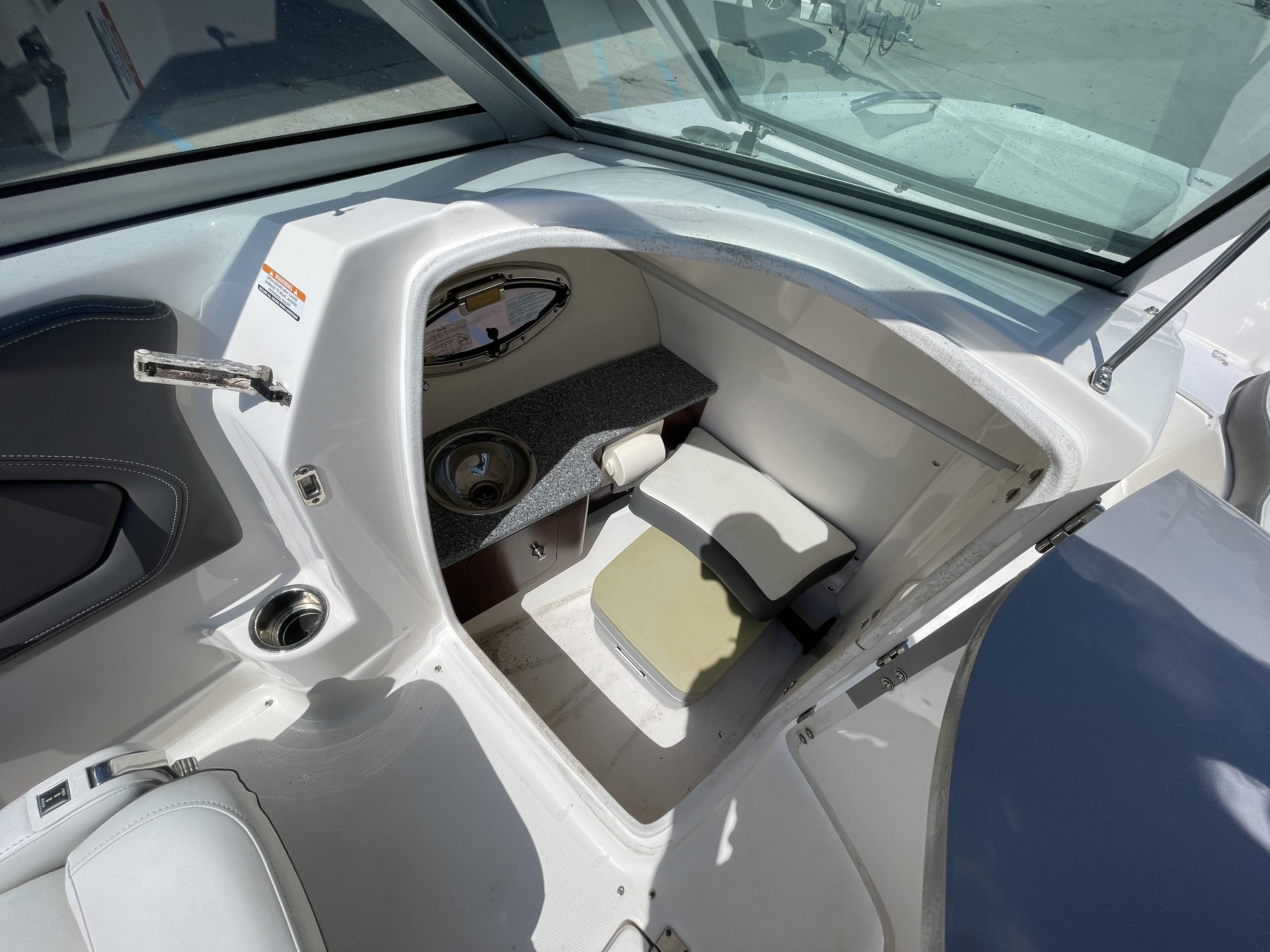 2014 Chaparral Sunesta 224 boat interior with seating and storage area.