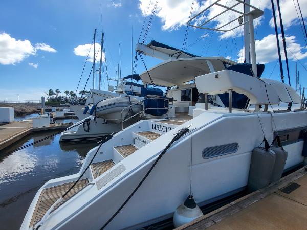 Catana 65 yacht, 2009 model, docked at marina under blue sky.