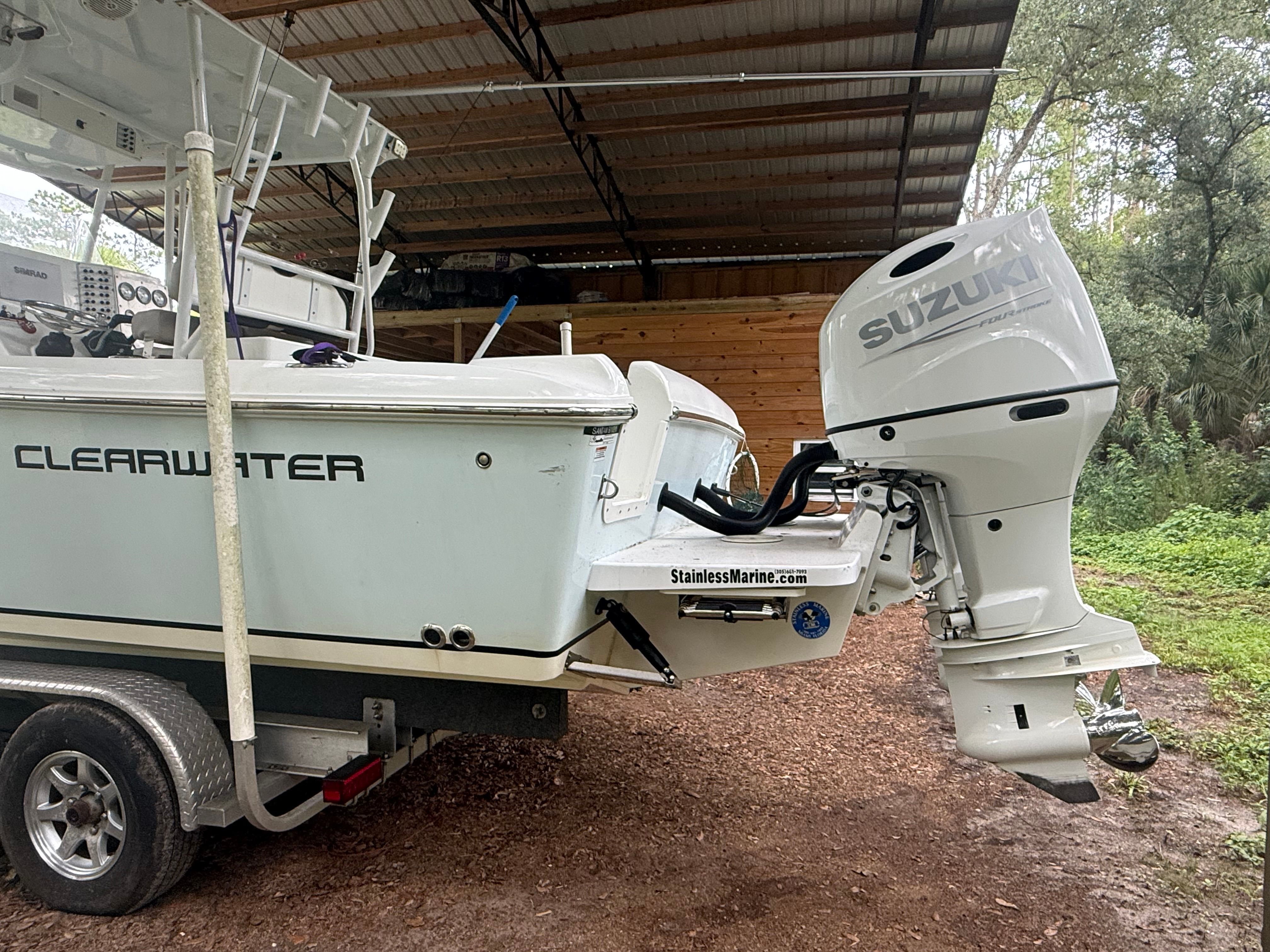 A 2021 Clearwater 2508 Center Console boat on a trailer with a Suzuki outboard motor.
