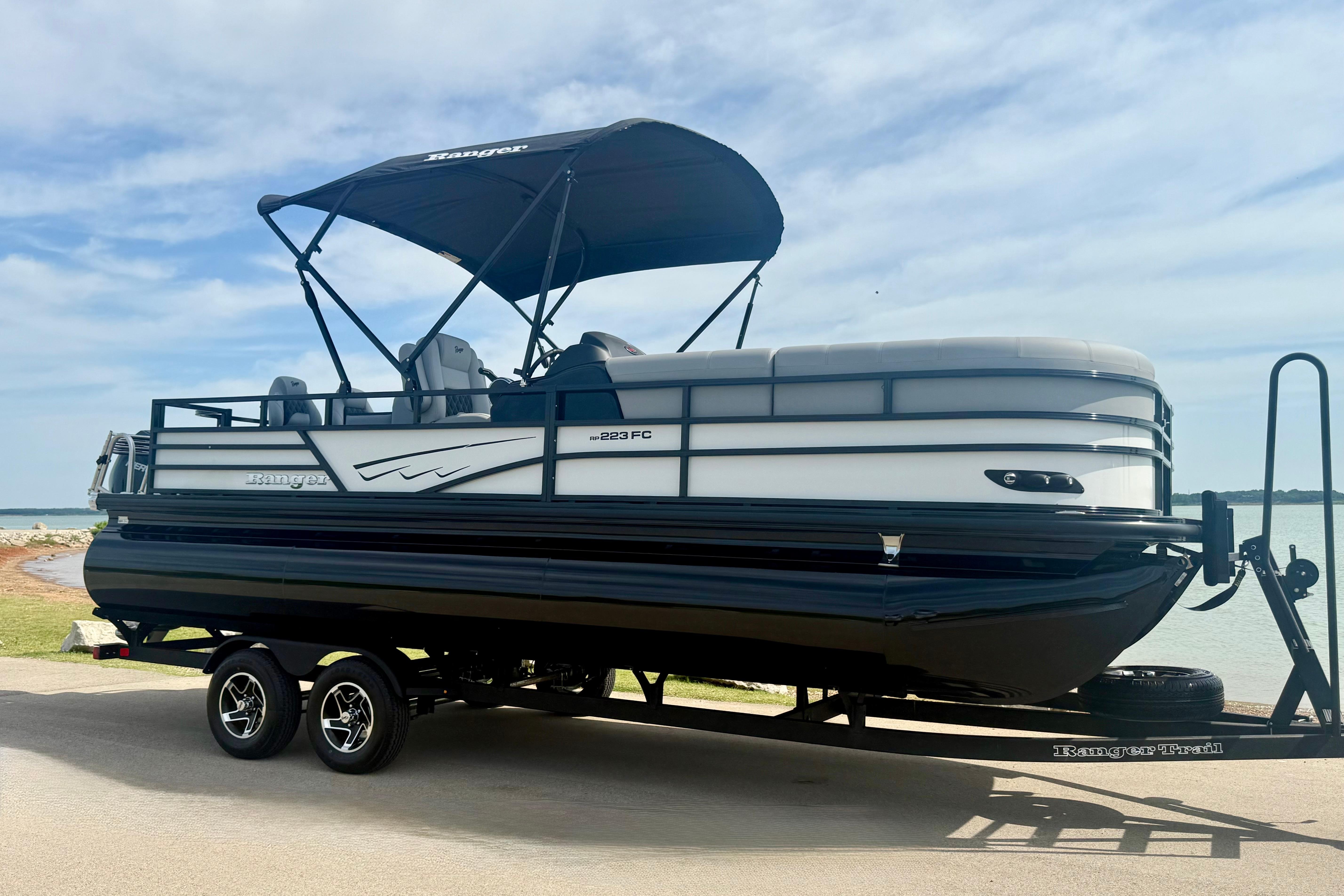 2026 Ranger 223FC pontoon boat on trailer by a lake.