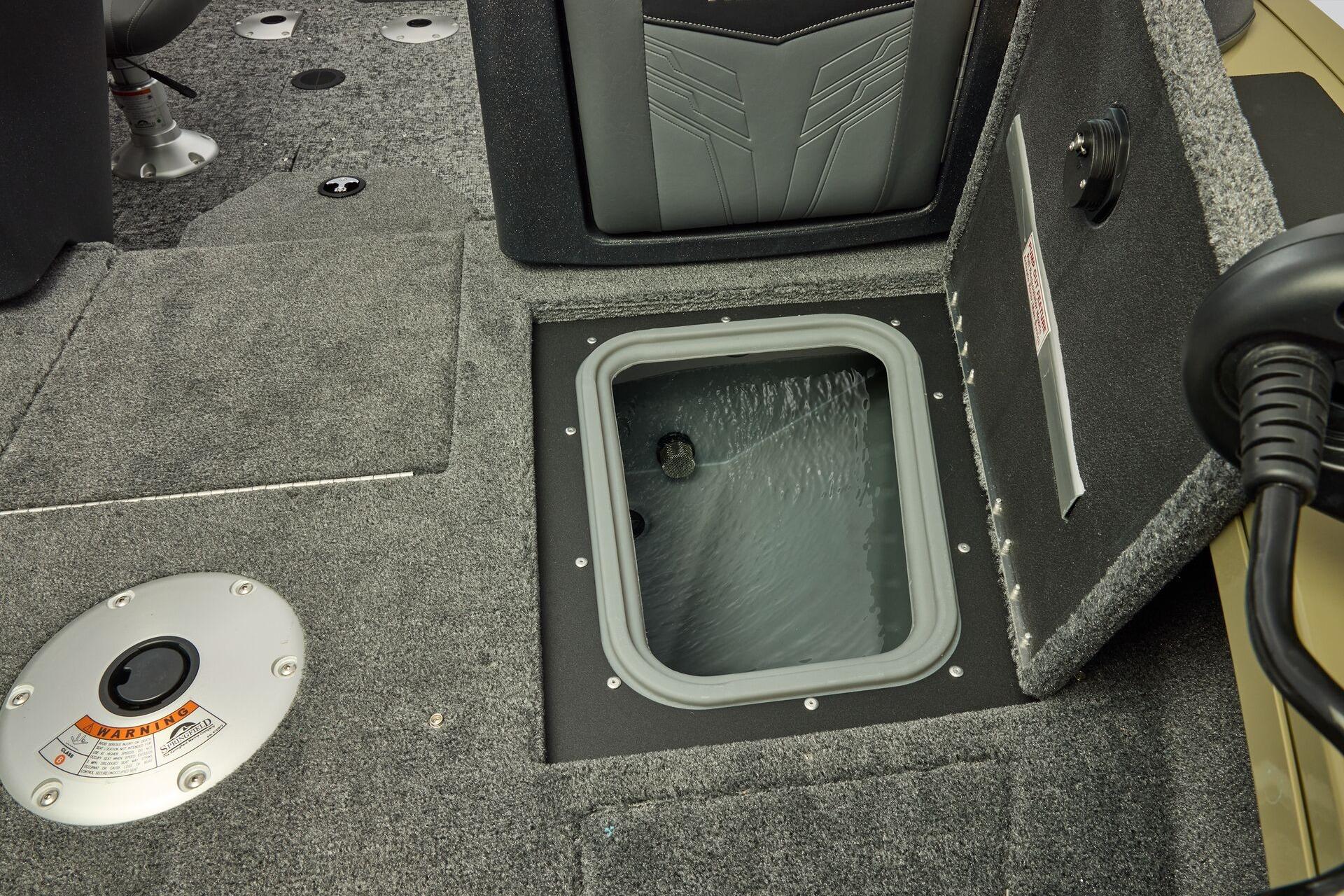 2026 Tracker Targa V-19 Combo boat interior with open storage compartment and carpeted flooring.