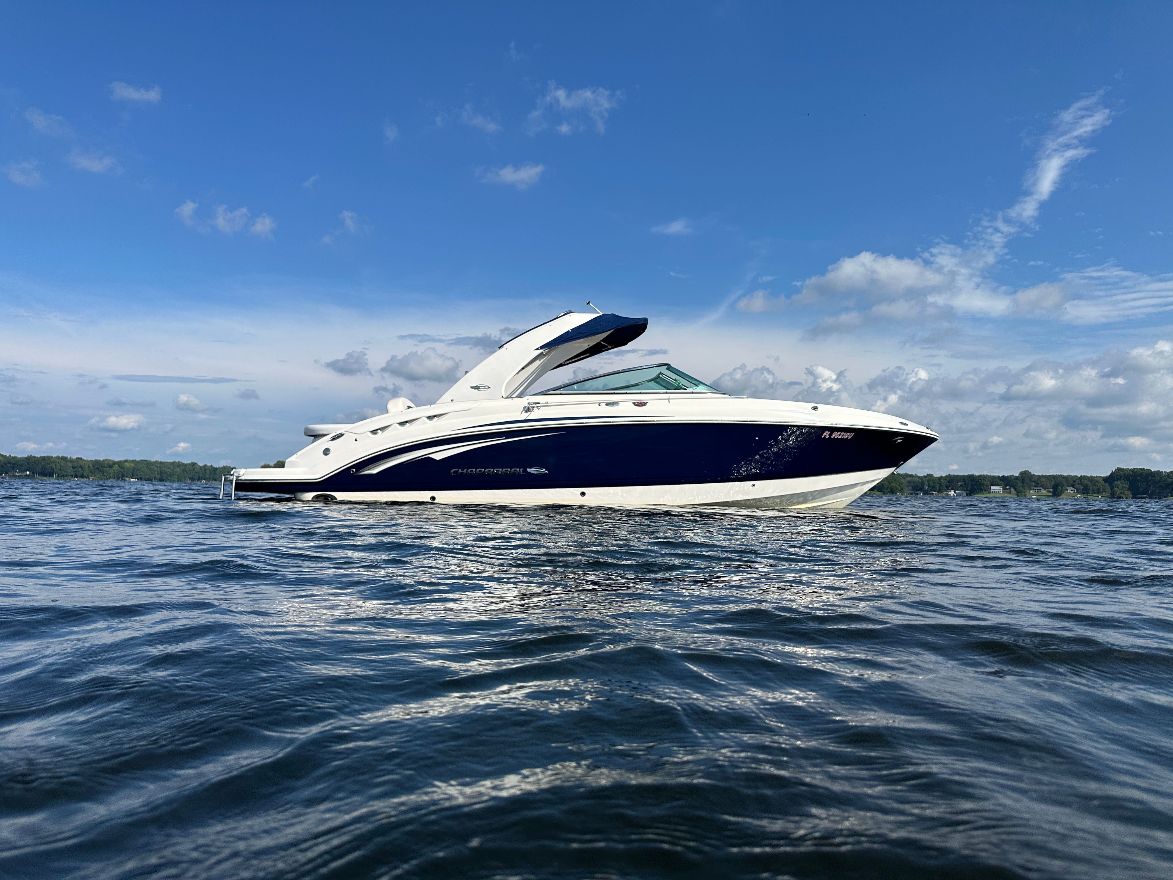 A 2011 Chaparral 287 SSX boat on calm water under a blue sky.