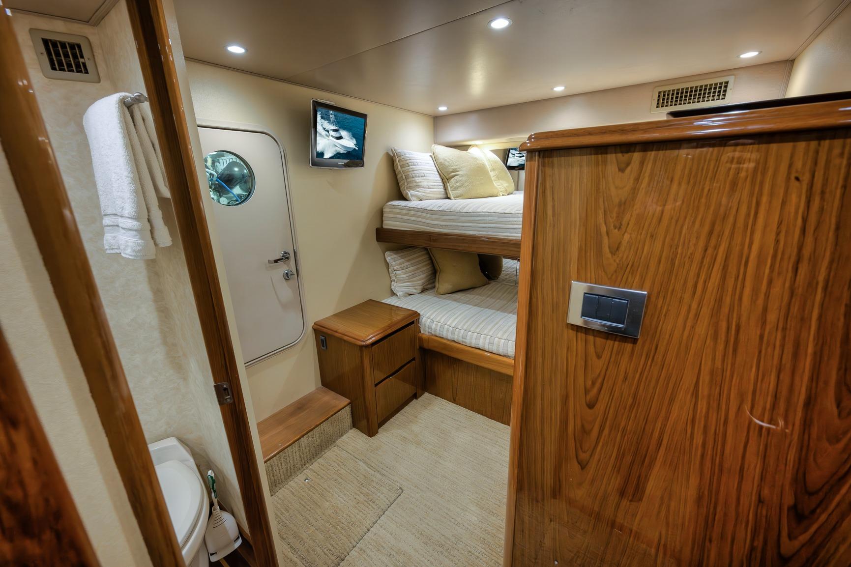Luxurious cabin interior of 2012 Viking 70 Enclosed Bridge yacht with bunk beds.