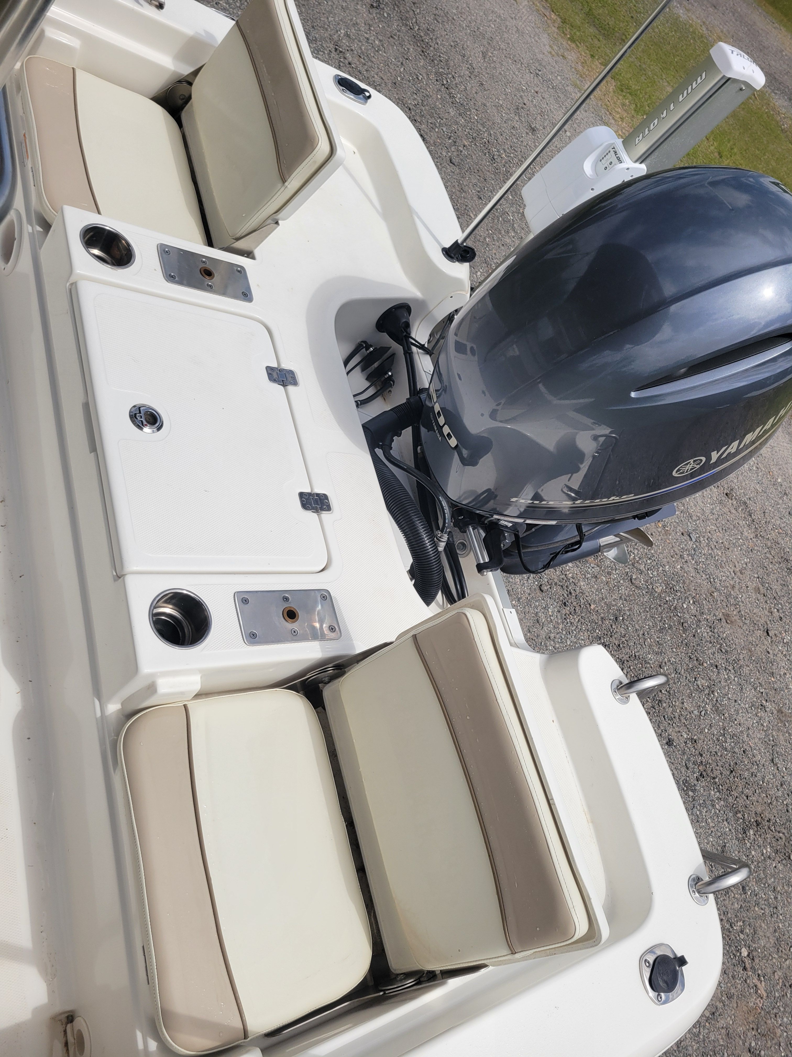 A boat with beige seats and an outboard motor on a trailer.