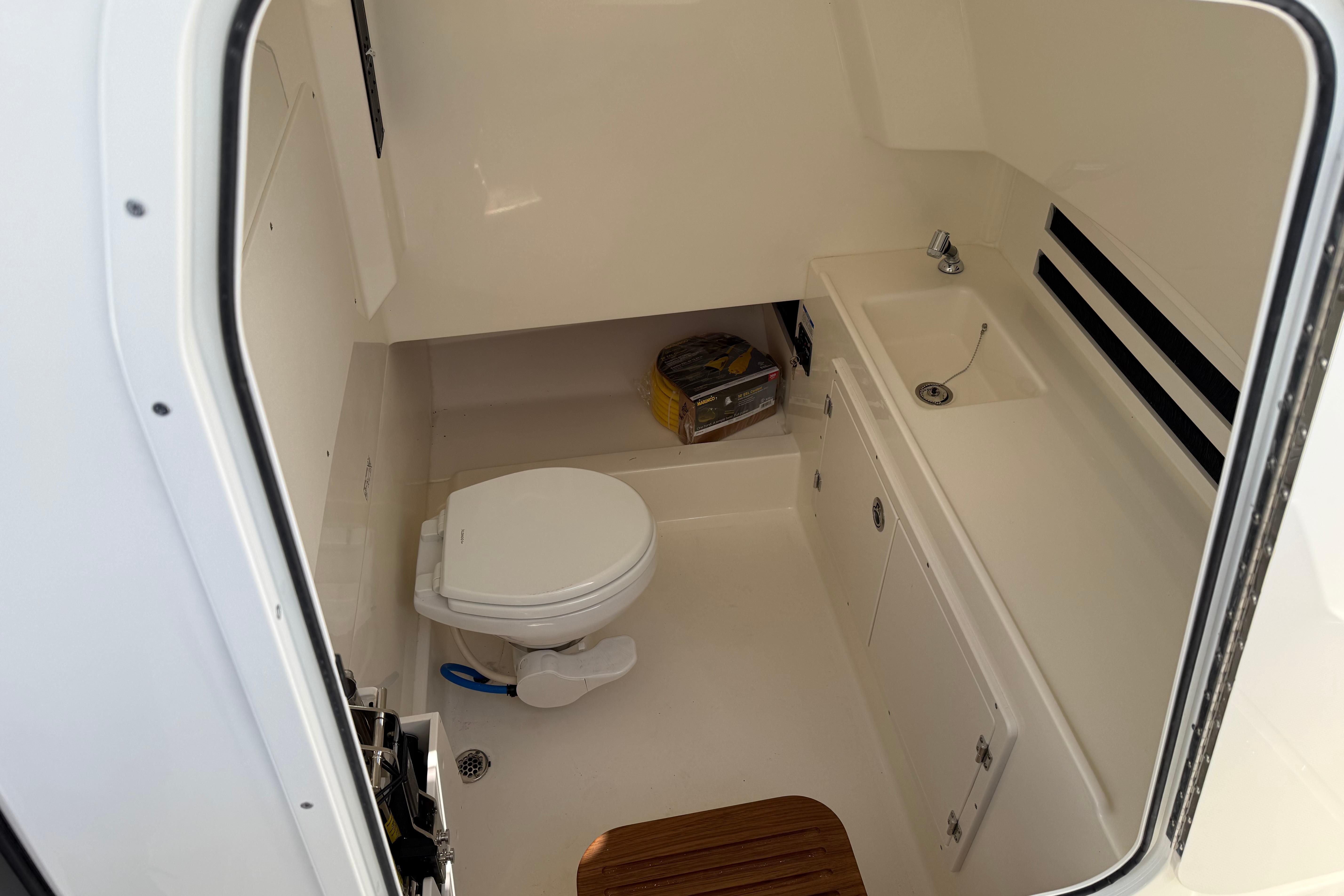 2026 Boston Whaler 330 Outrage boat interior with toilet and sink.