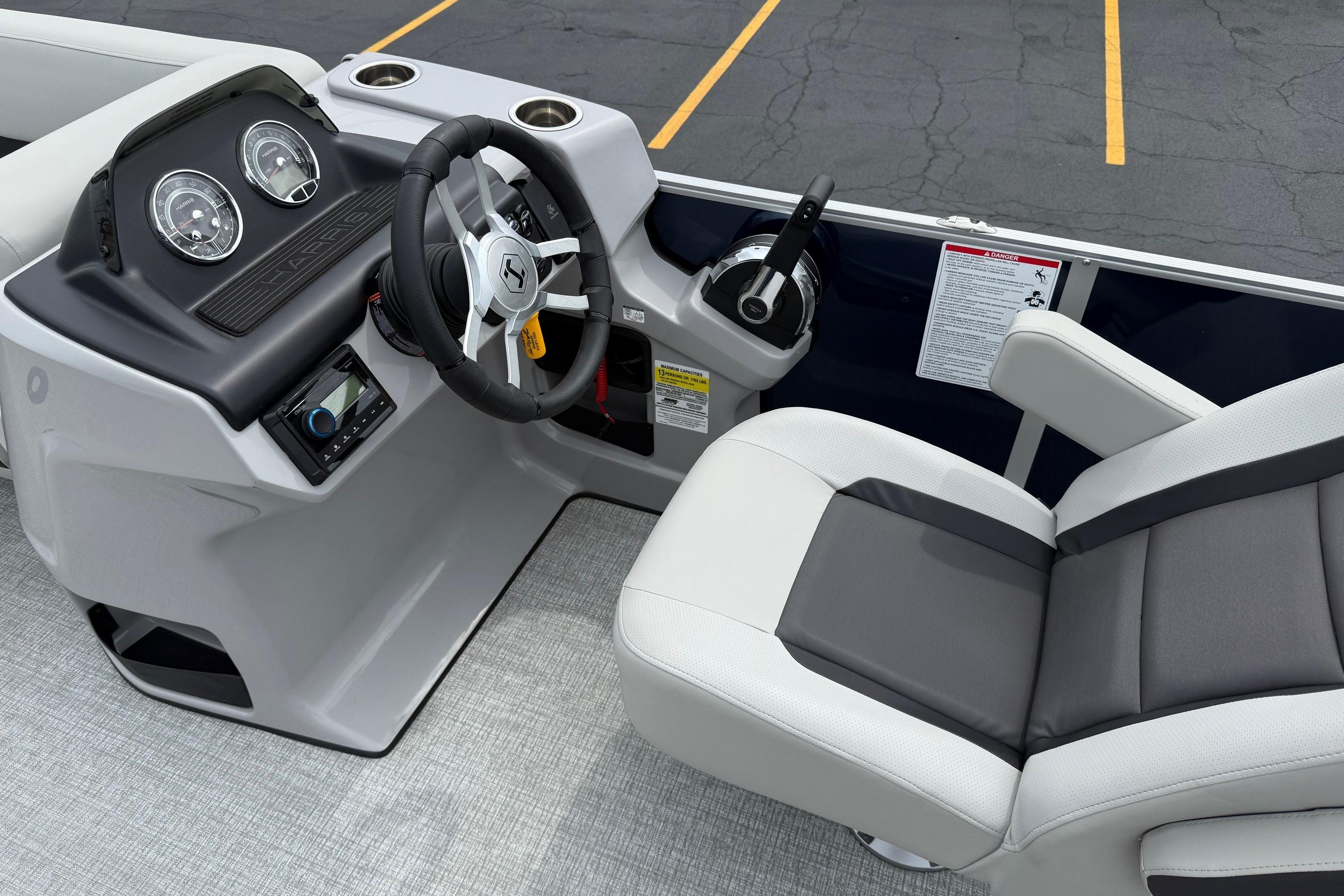 2025 Harris Cruiser 230 boat helm with steering wheel and comfortable seating.