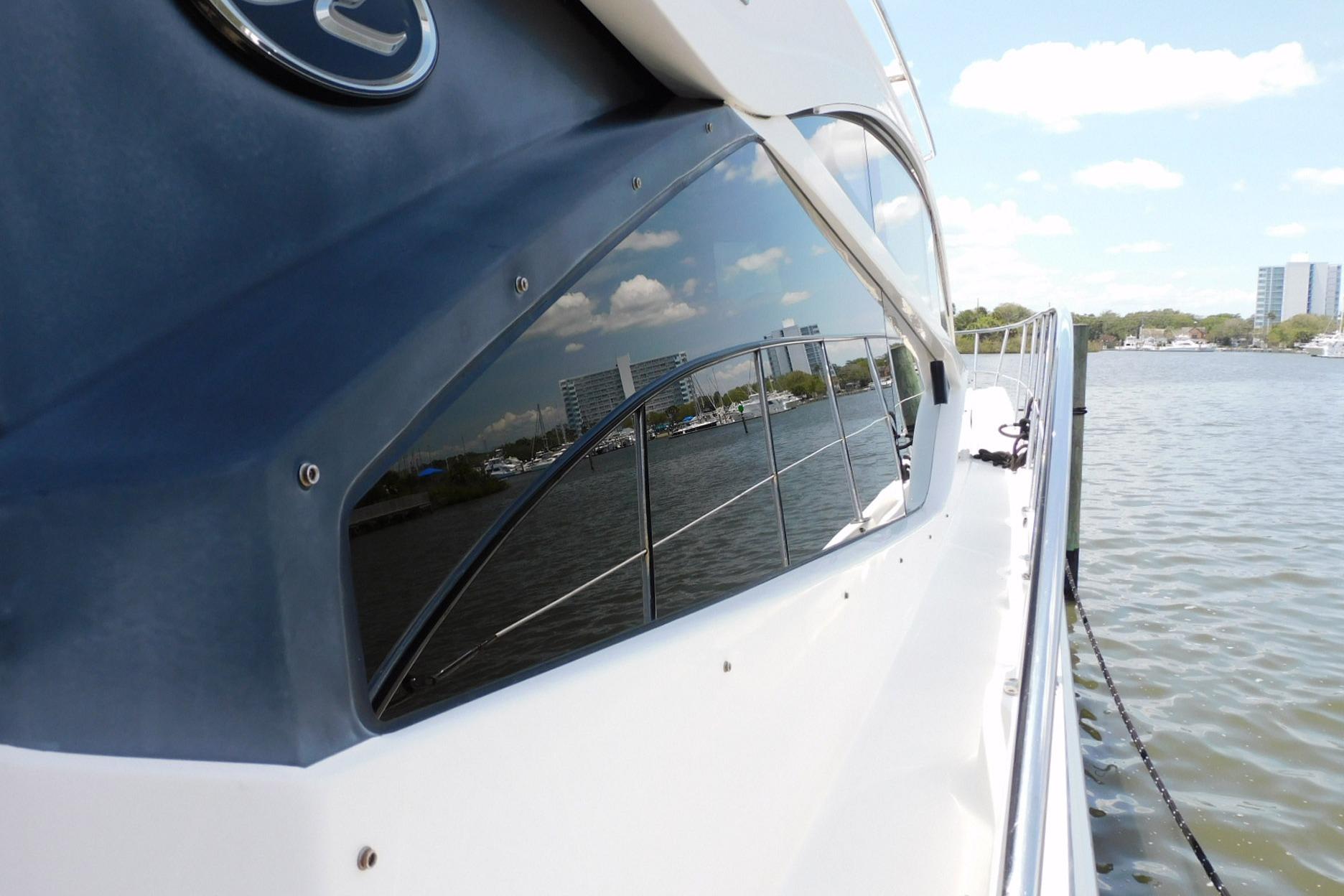 2019 Sea Ray L550 yacht reflecting cityscape on calm water.