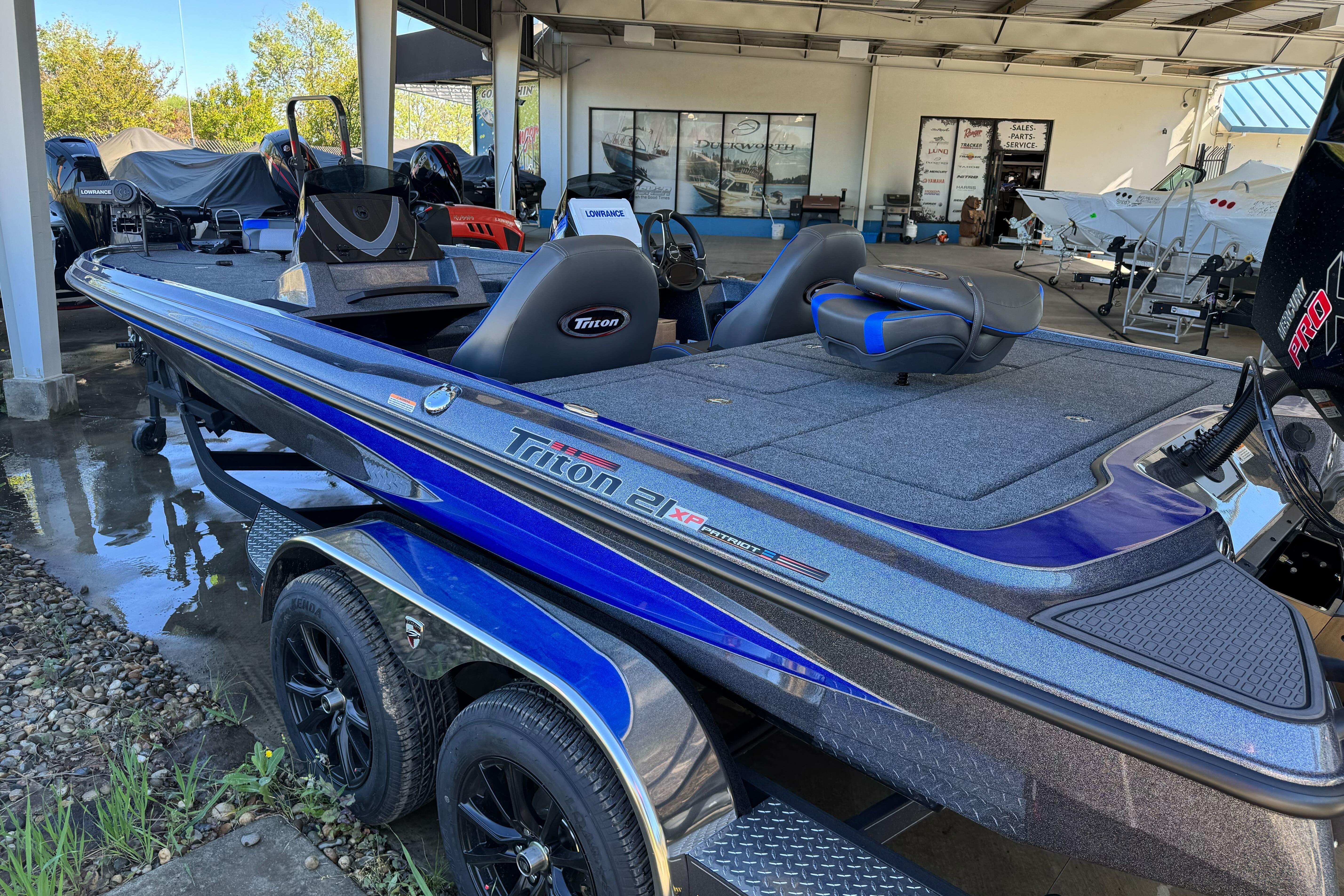 2026 Triton 21XP Patriot boat in showroom, featuring sleek design and dual seats.
