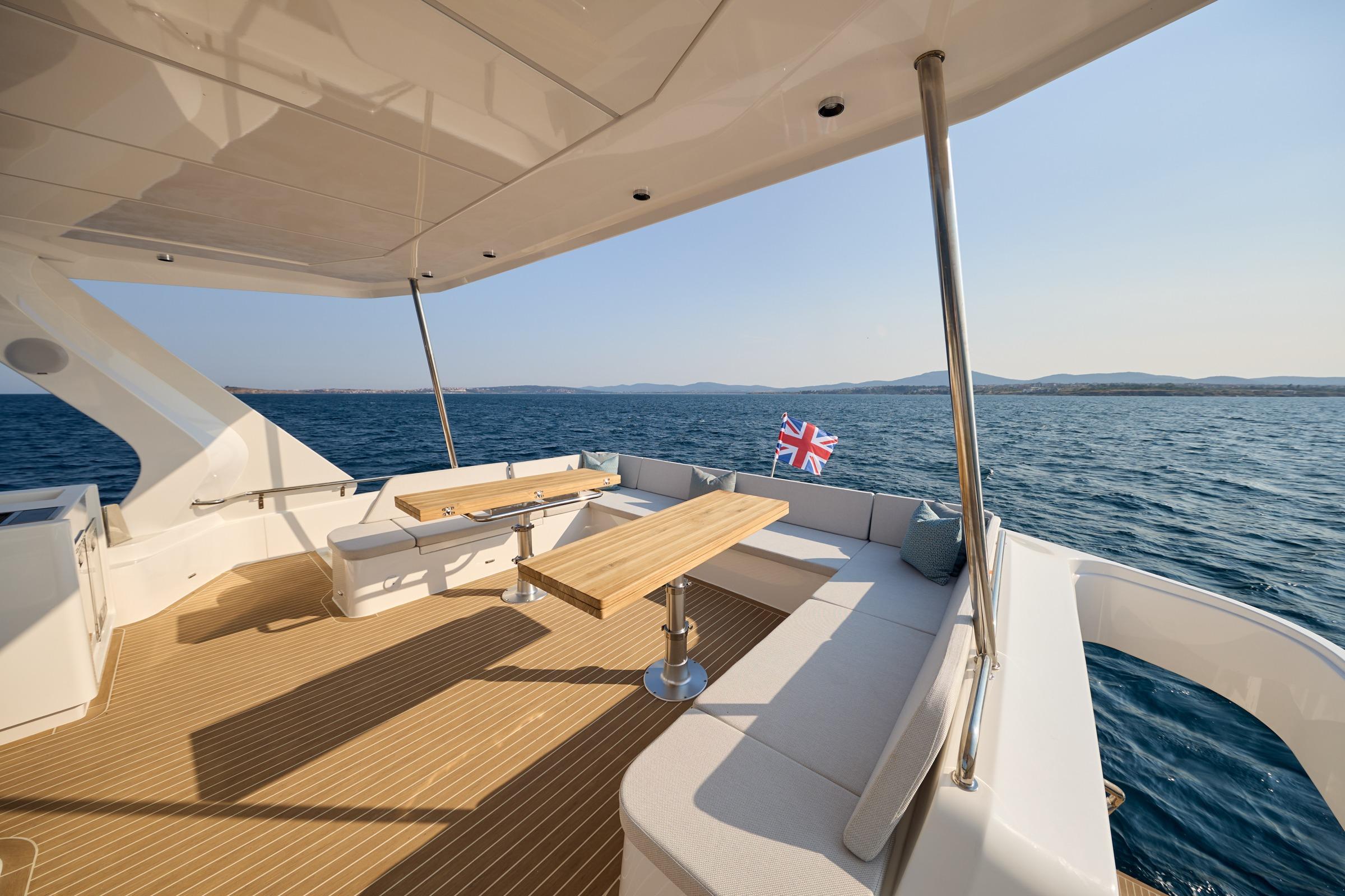 Luxurious 2025 Omaya 50 Power Catamaran deck with seating, table, and ocean view.