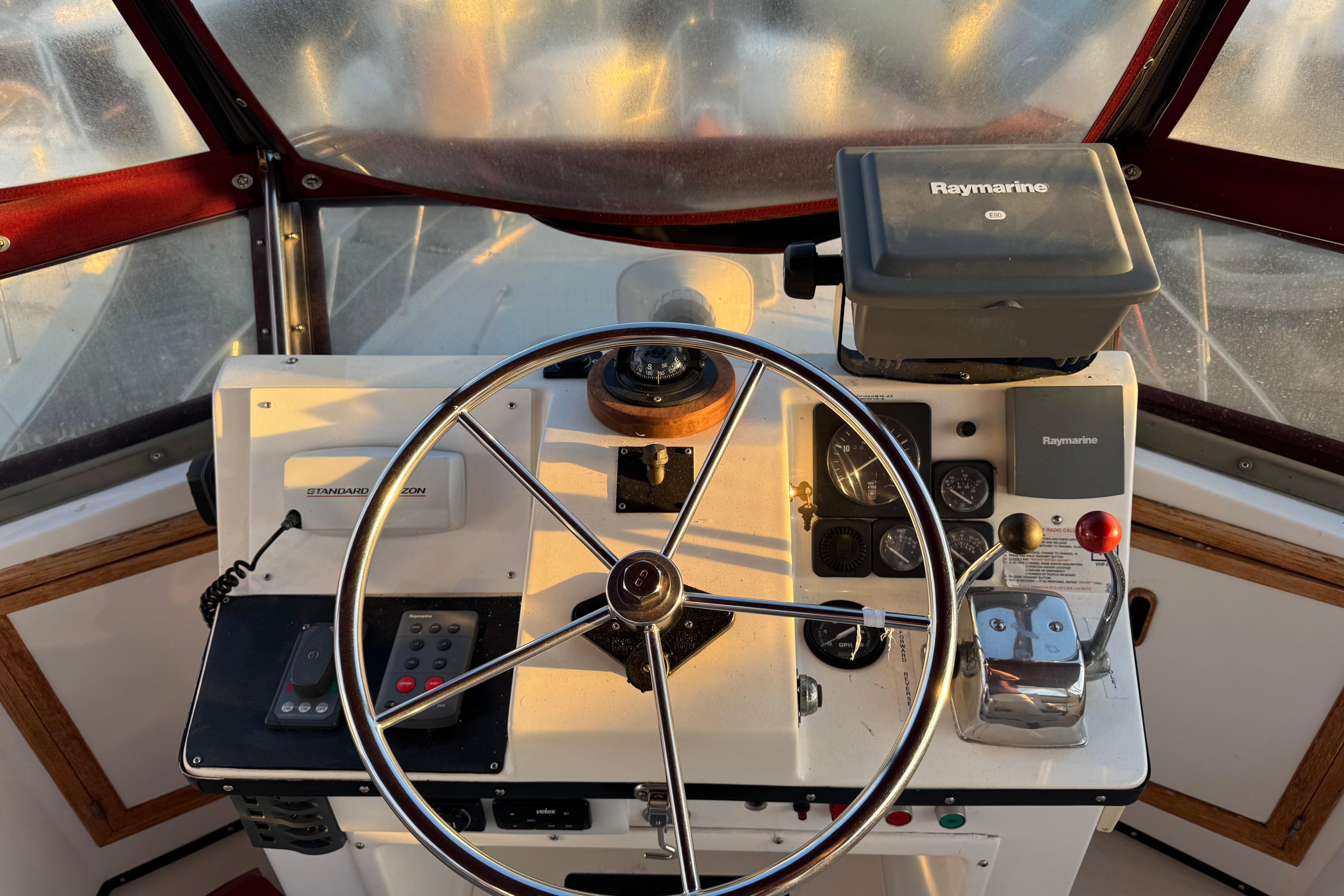 Helm of a 1987 President 37 boat with steering wheel and navigation equipment.