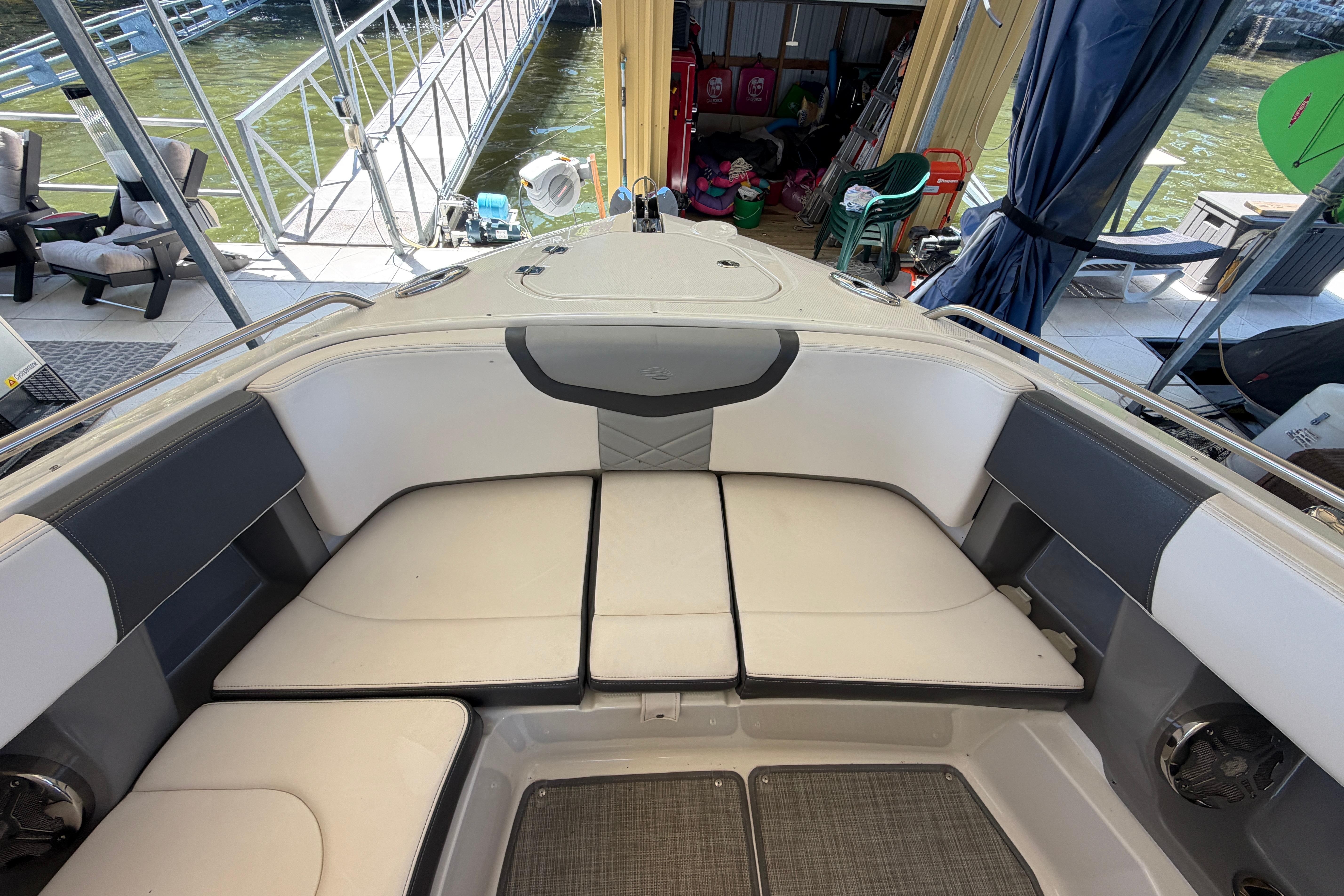 Interior view of 2018 Chaparral 347 SSX boat with cushioned seating and dockside setting.