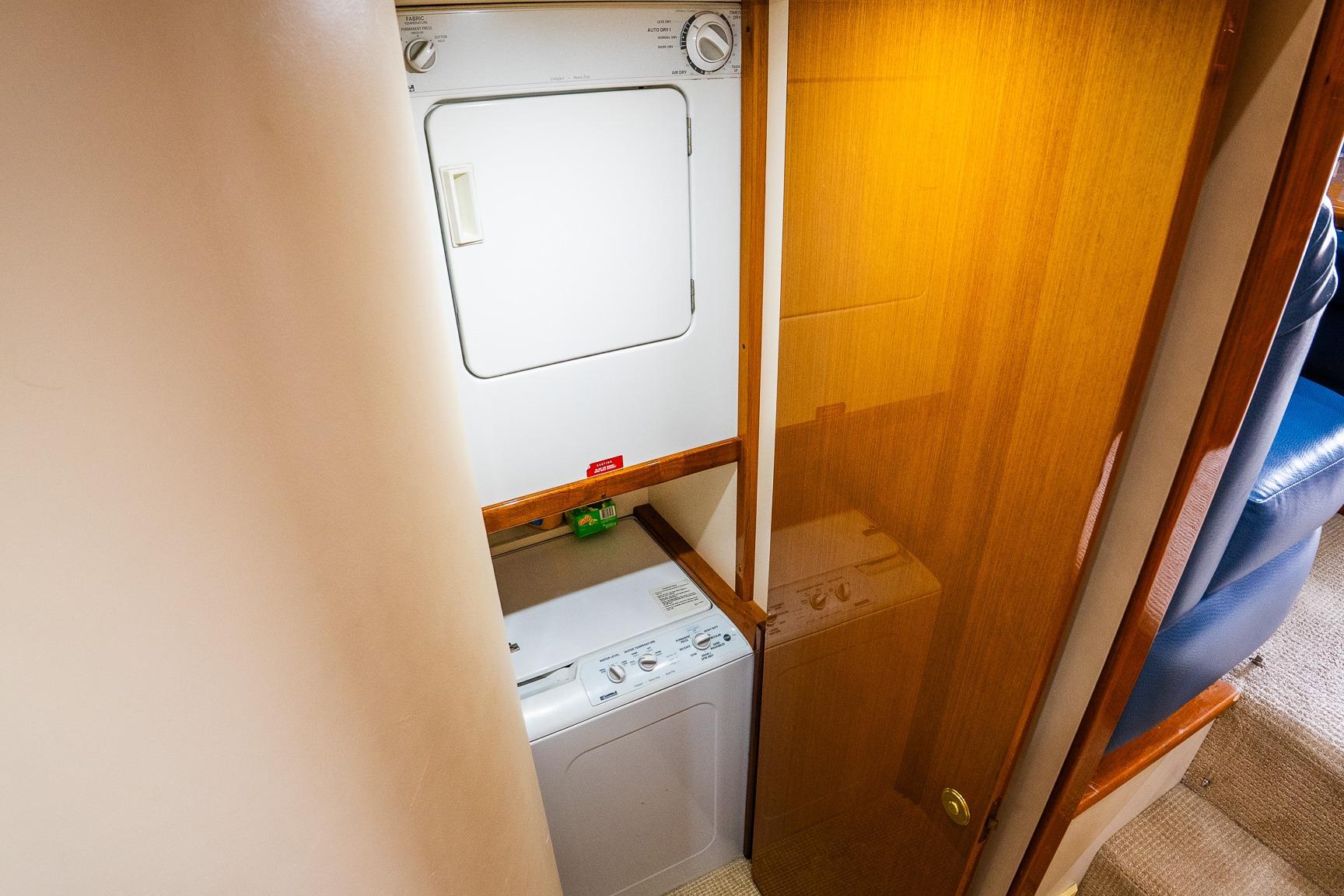 Laundry area on 2002 Viking 61 Enclosed Bridge yacht with stacked washer and dryer.