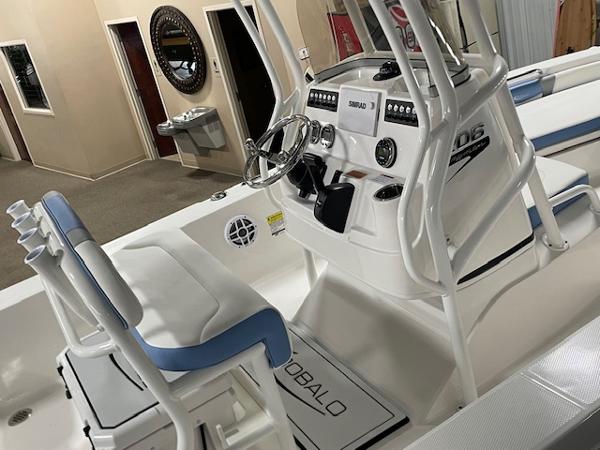 2025 Robalo 206 Cayman boat interior with steering console and seating in showroom.