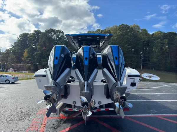 2024 Fountain 34 SC boat with triple outboard engines in a parking lot.