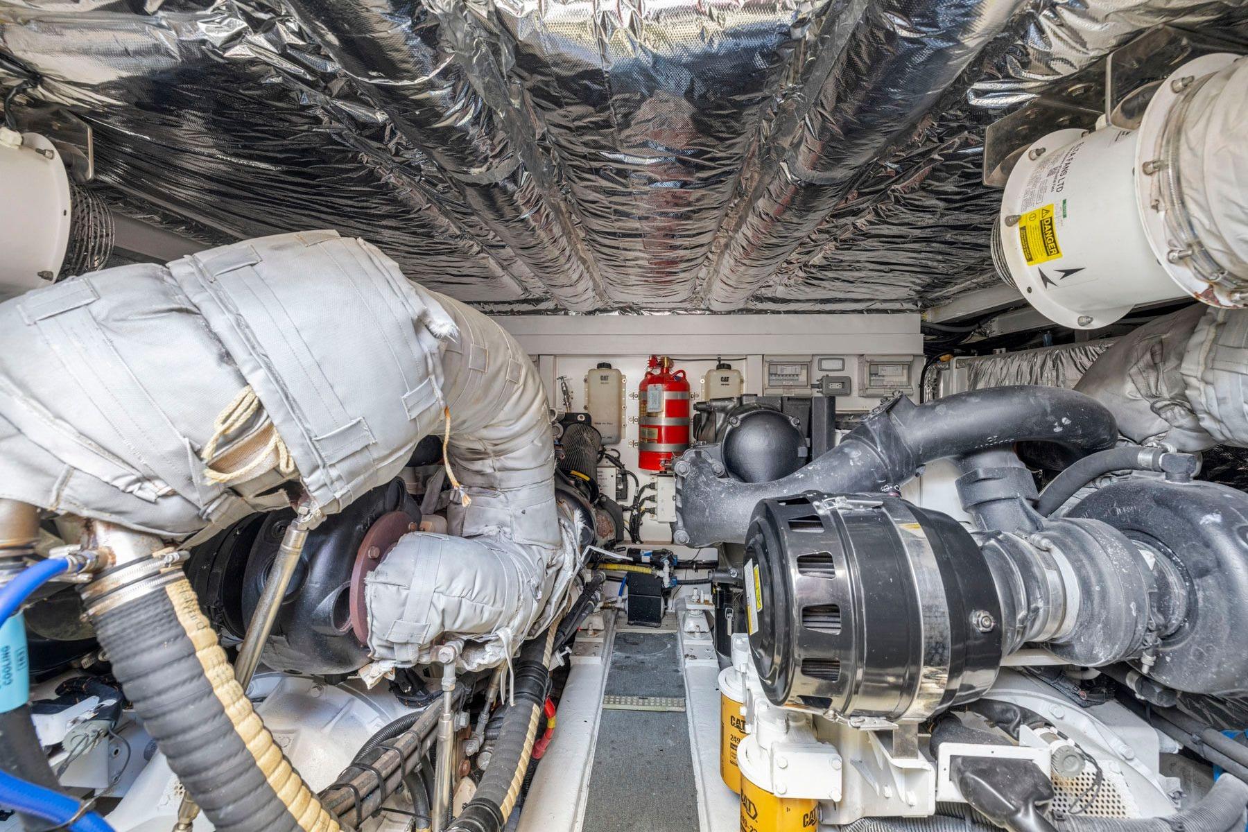 Engine room of 2015 Princess 60 Flybridge Motor Yacht, showcasing complex machinery and insulation.