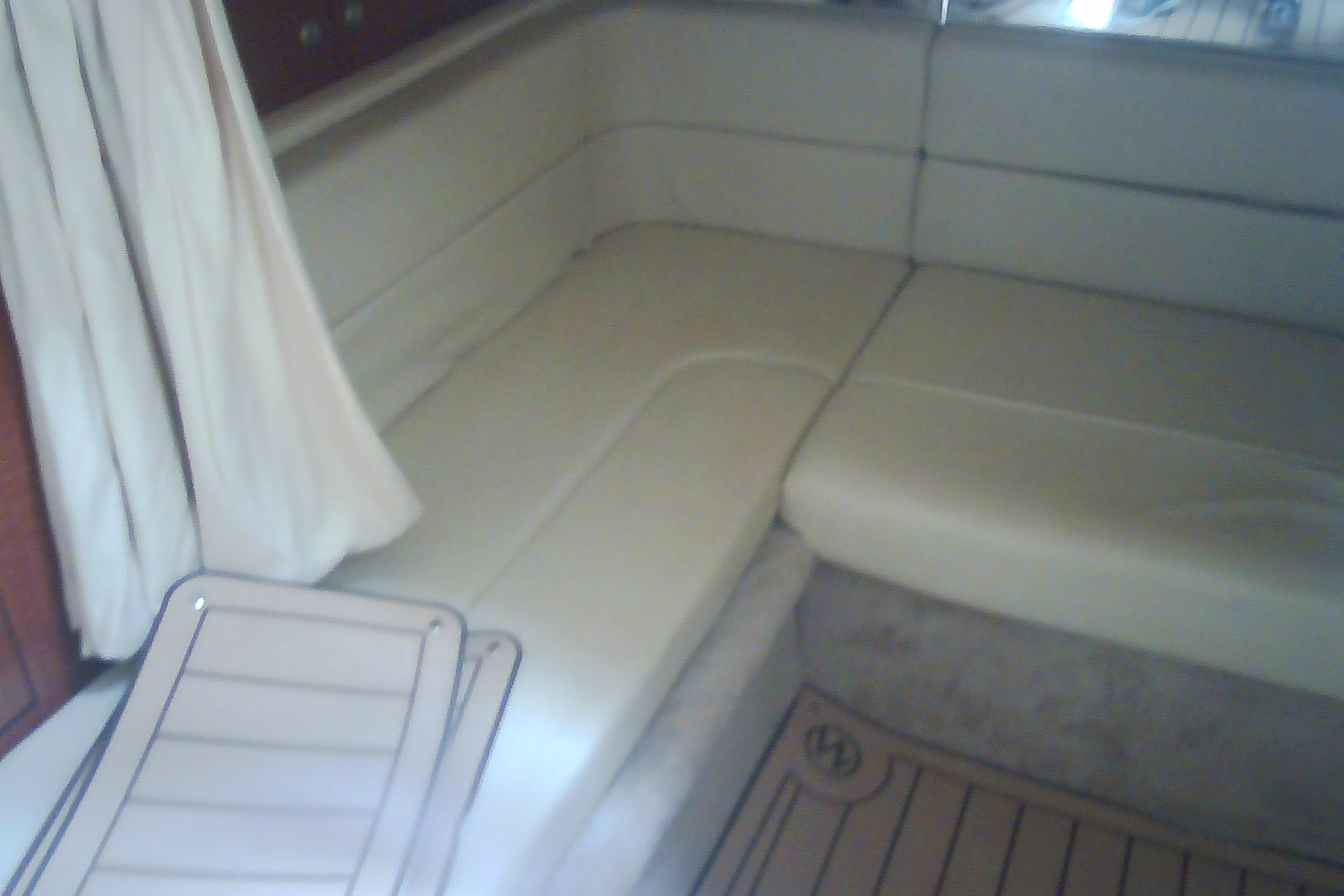 Interior seating of 2005 Sea Ray 300 Sundancer with beige upholstery and wooden accents.