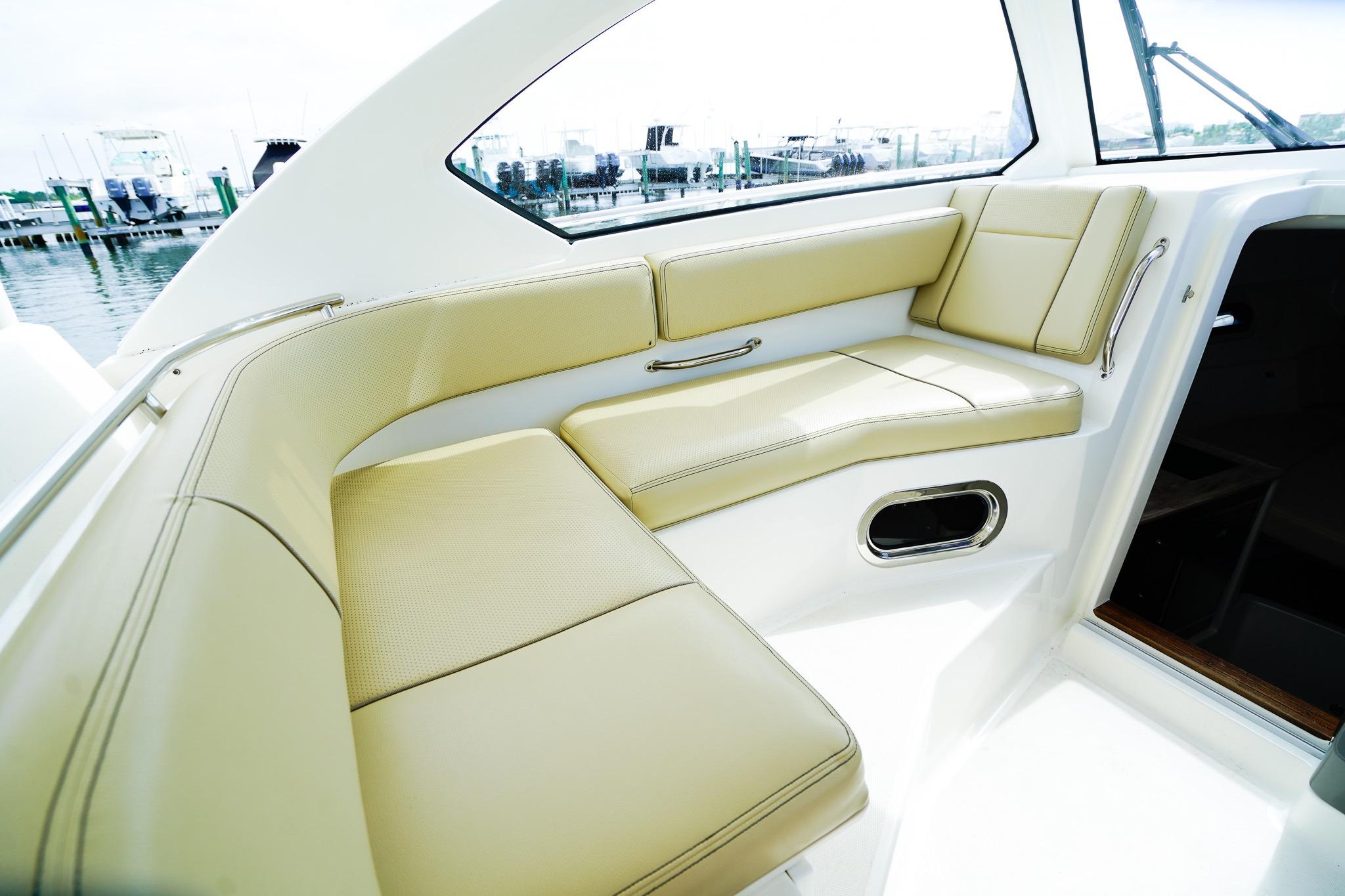 Luxurious seating area on a 2020 Pursuit OS 325 Offshore boat, docked at a marina.