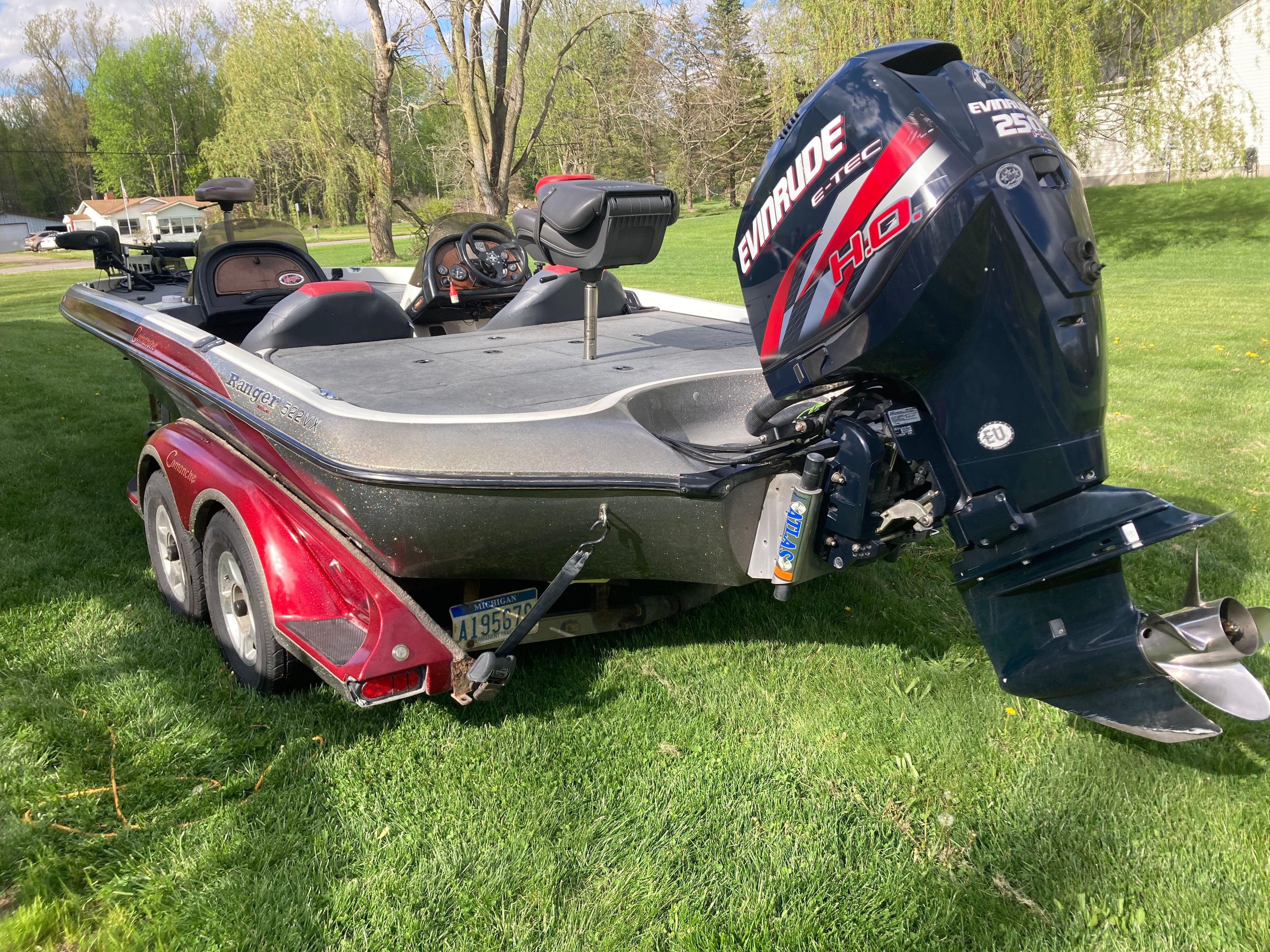 A 2002 Ranger 522DVX Comanche boat on grass, featuring an Evinrude motor.