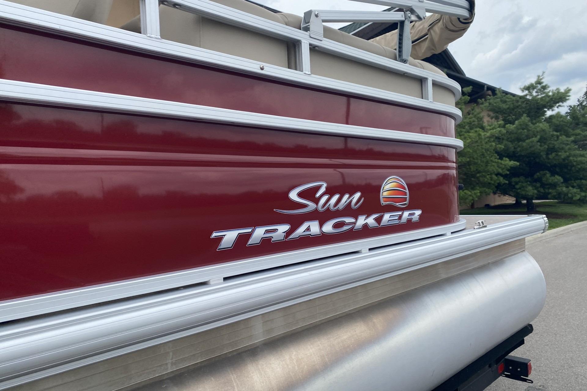 2024 Sun Tracker Party Barge 22 DLX pontoon boat with red exterior and logo.
