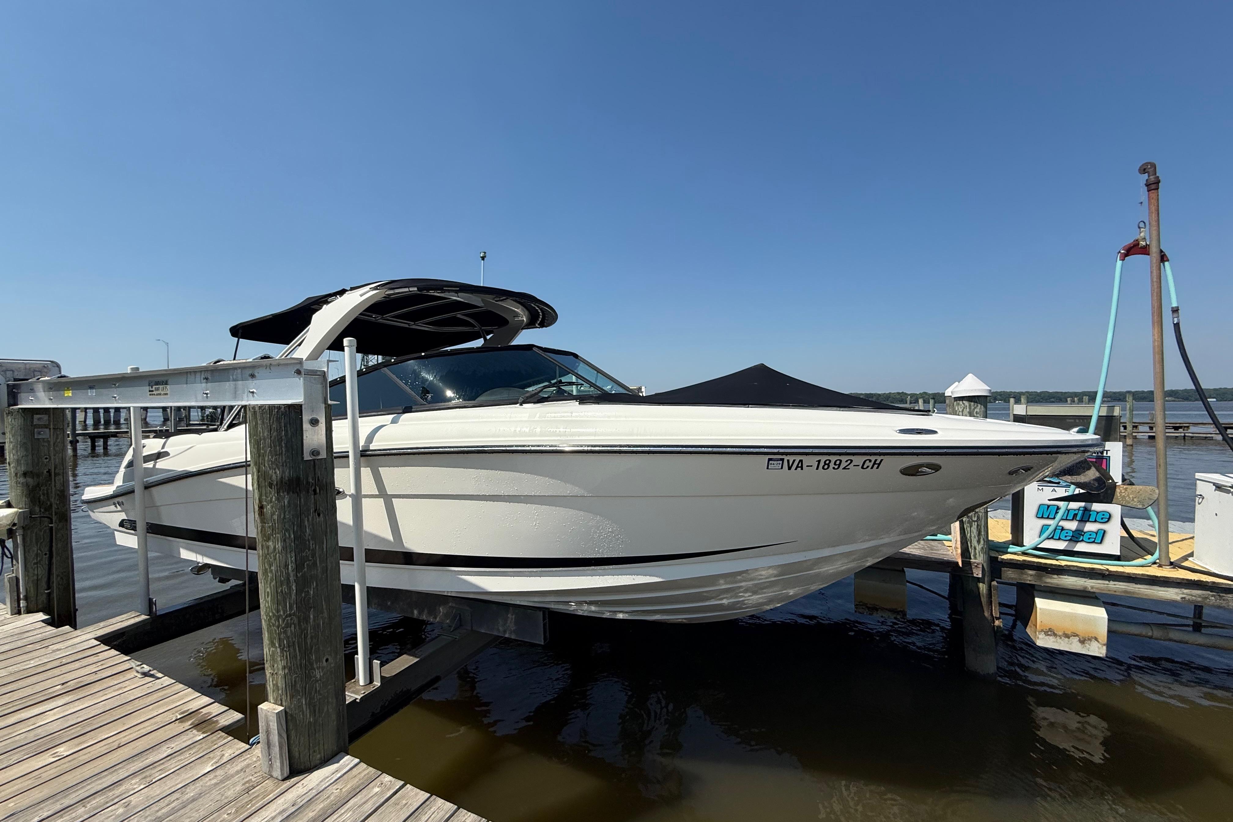 2011 Sea Ray 270 SLX boat docked at a marina under clear blue skies.