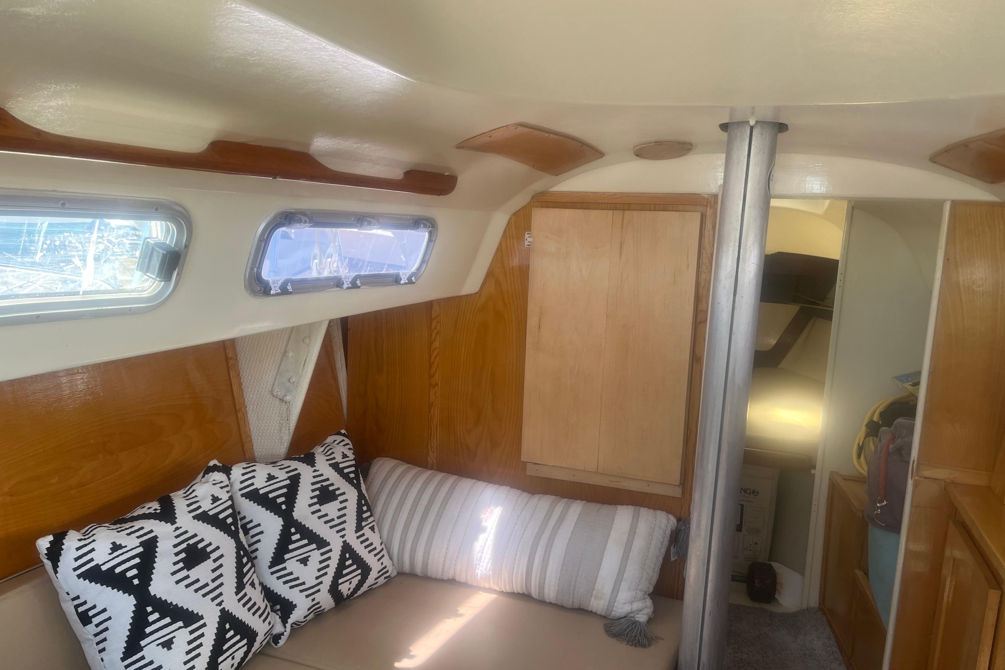 Interior of a 1972 C&C 30 sailboat with cozy seating and decorative pillows.