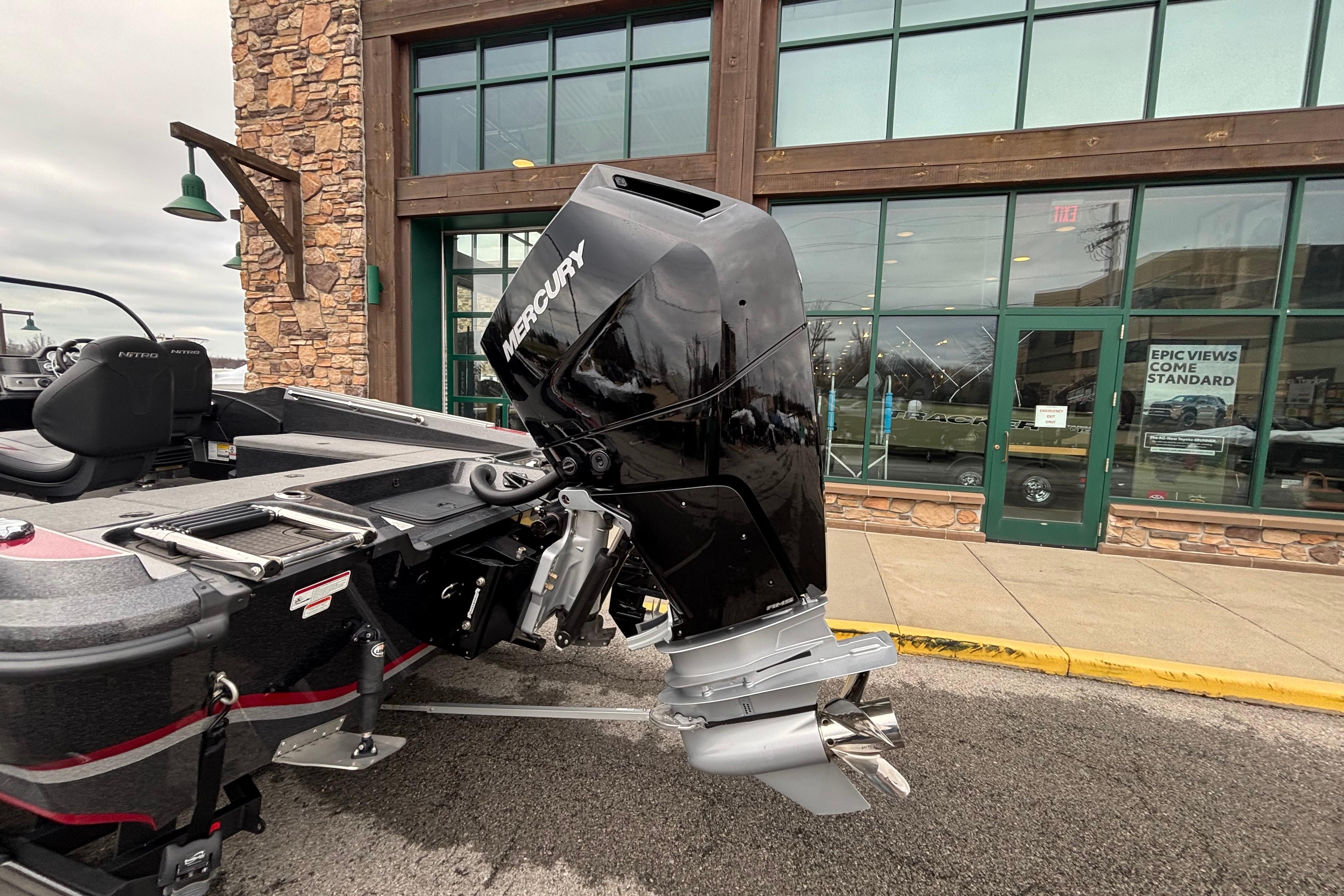 2024 Nitro ZV21 Pro boat with Mercury outboard motor, parked outside a building.