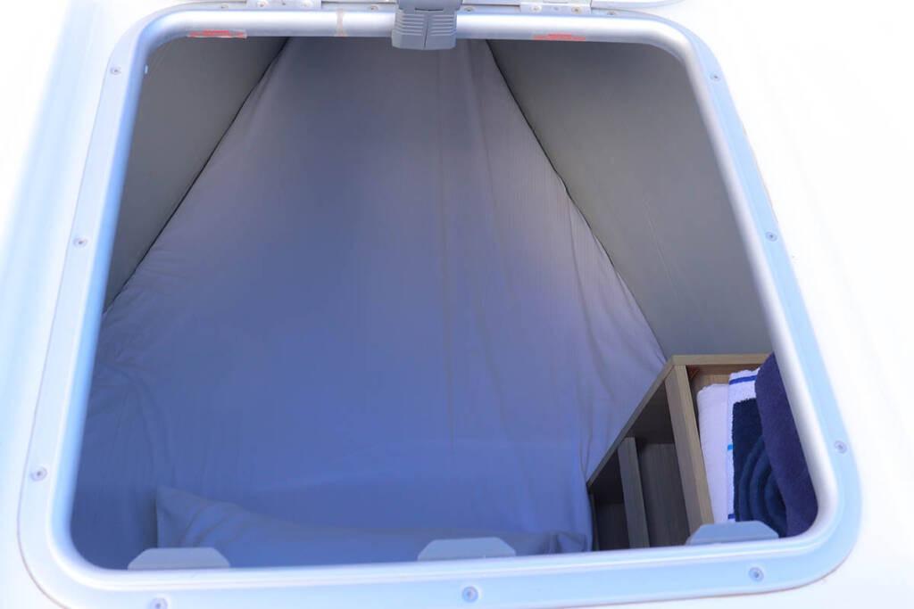 2023 Lagoon 46 yacht cabin interior with bedding and storage space.