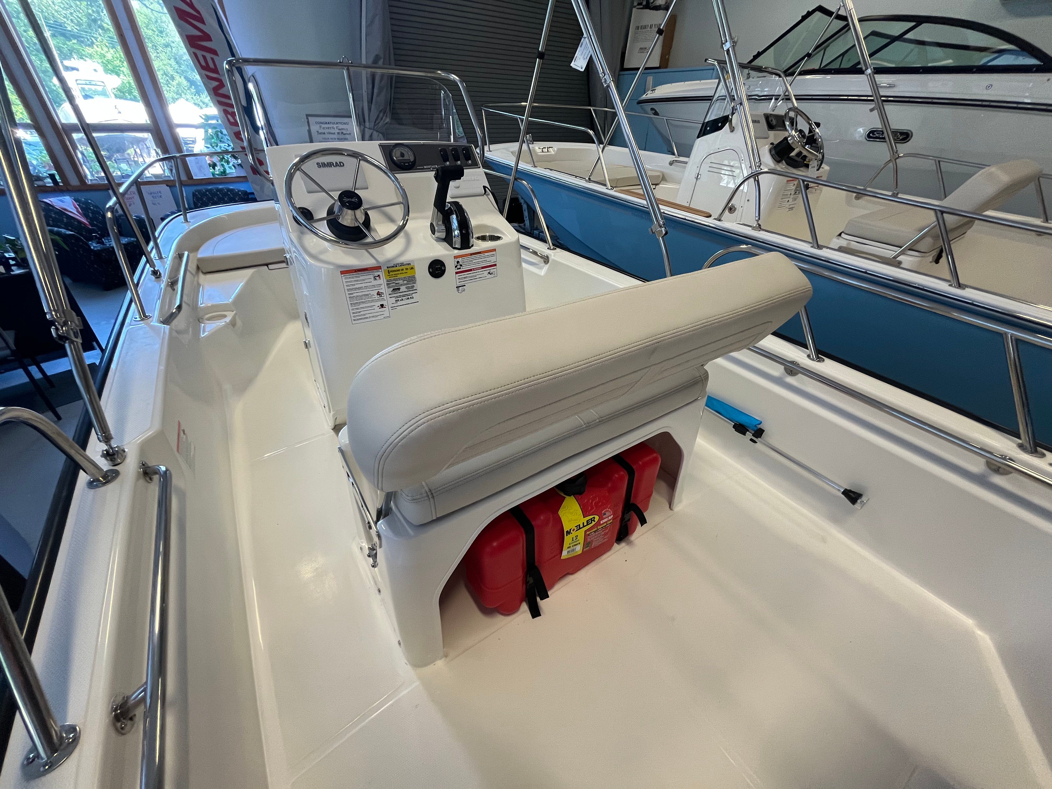 The image shows the cockpit of a Boston Whaler 150 Montauk with a helm and seating.