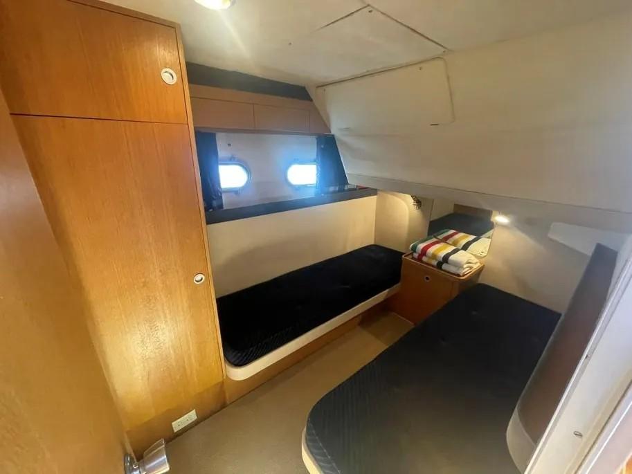 1985 Princess Sedan Flybridge cabin with twin beds and wooden interior.