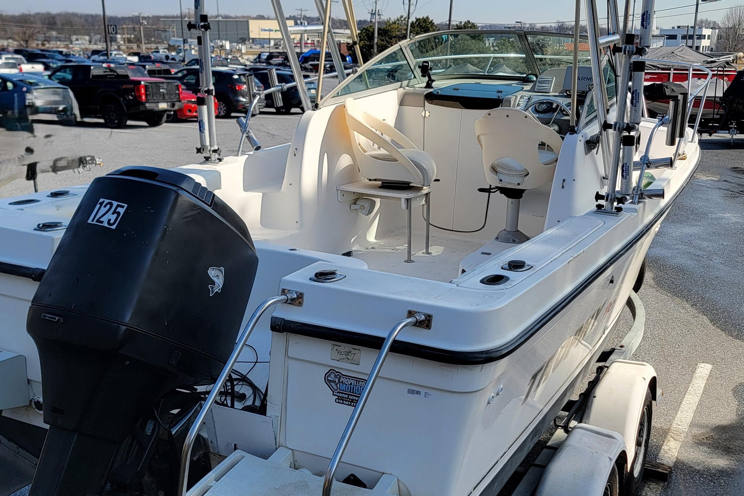 2003 Trophy 2002 Walkaround boat with outboard motor in parking lot.