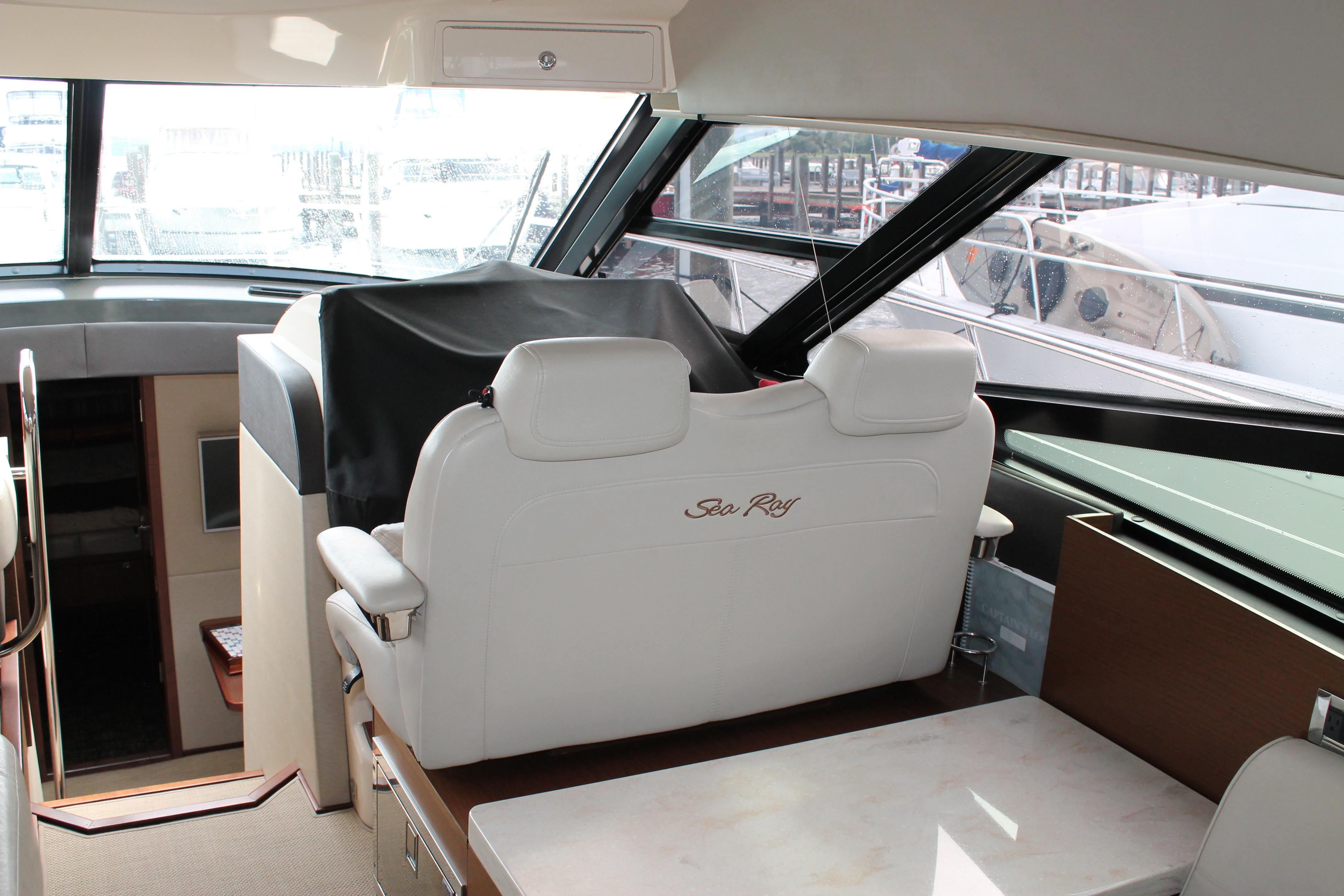 Interior of 2015 Sea Ray 470 Sundancer yacht with white seating and helm station.