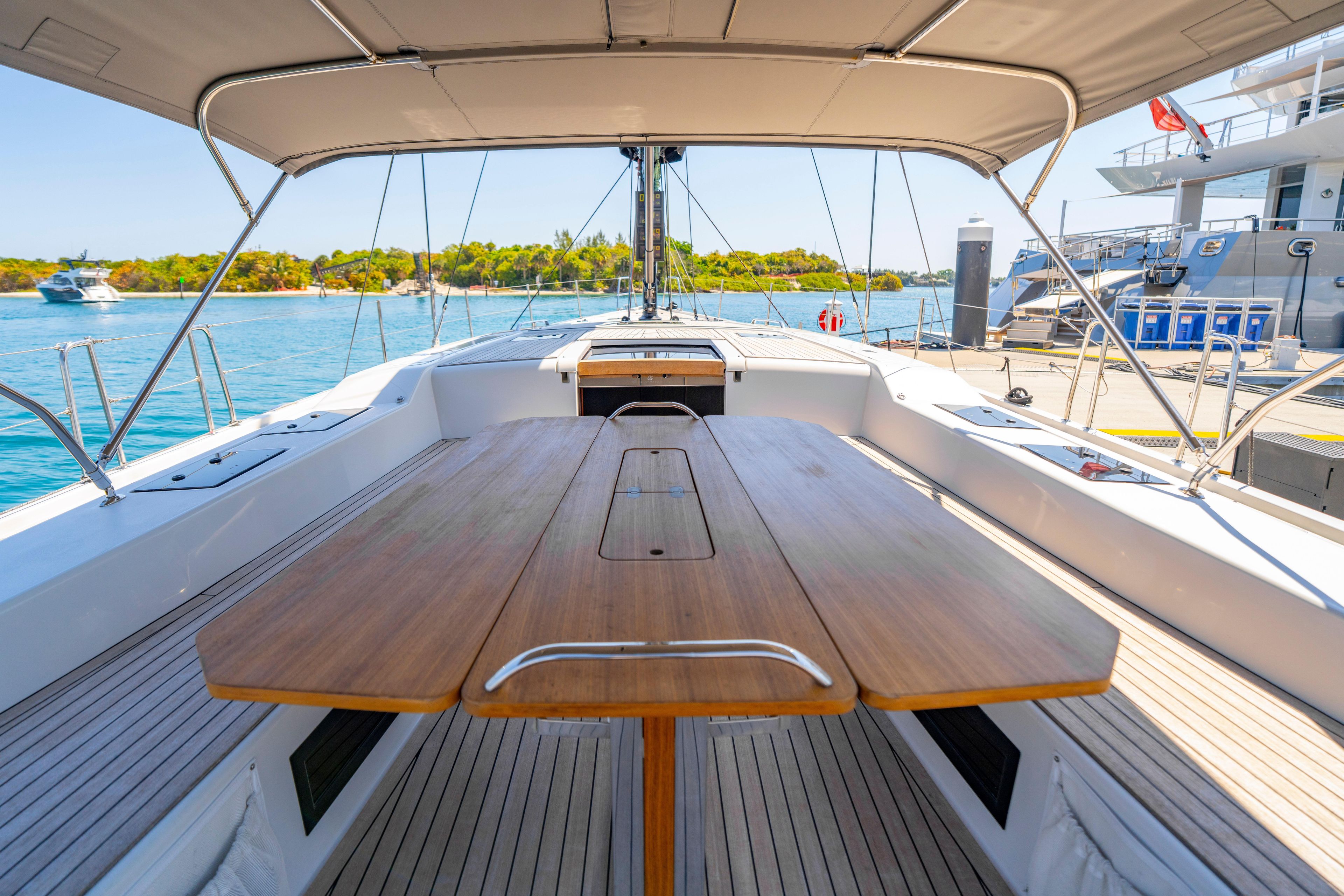 Grand Soleil 58 yacht cockpit with wooden table, docked by clear blue water, 2016 model.