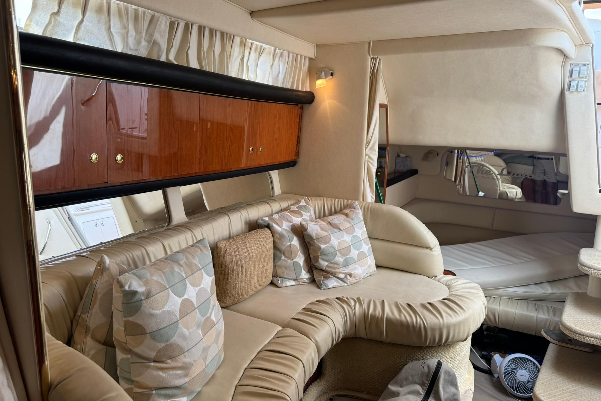 Interior of 2001 Sea Ray 340 Sundancer yacht with plush seating and elegant wood cabinetry.