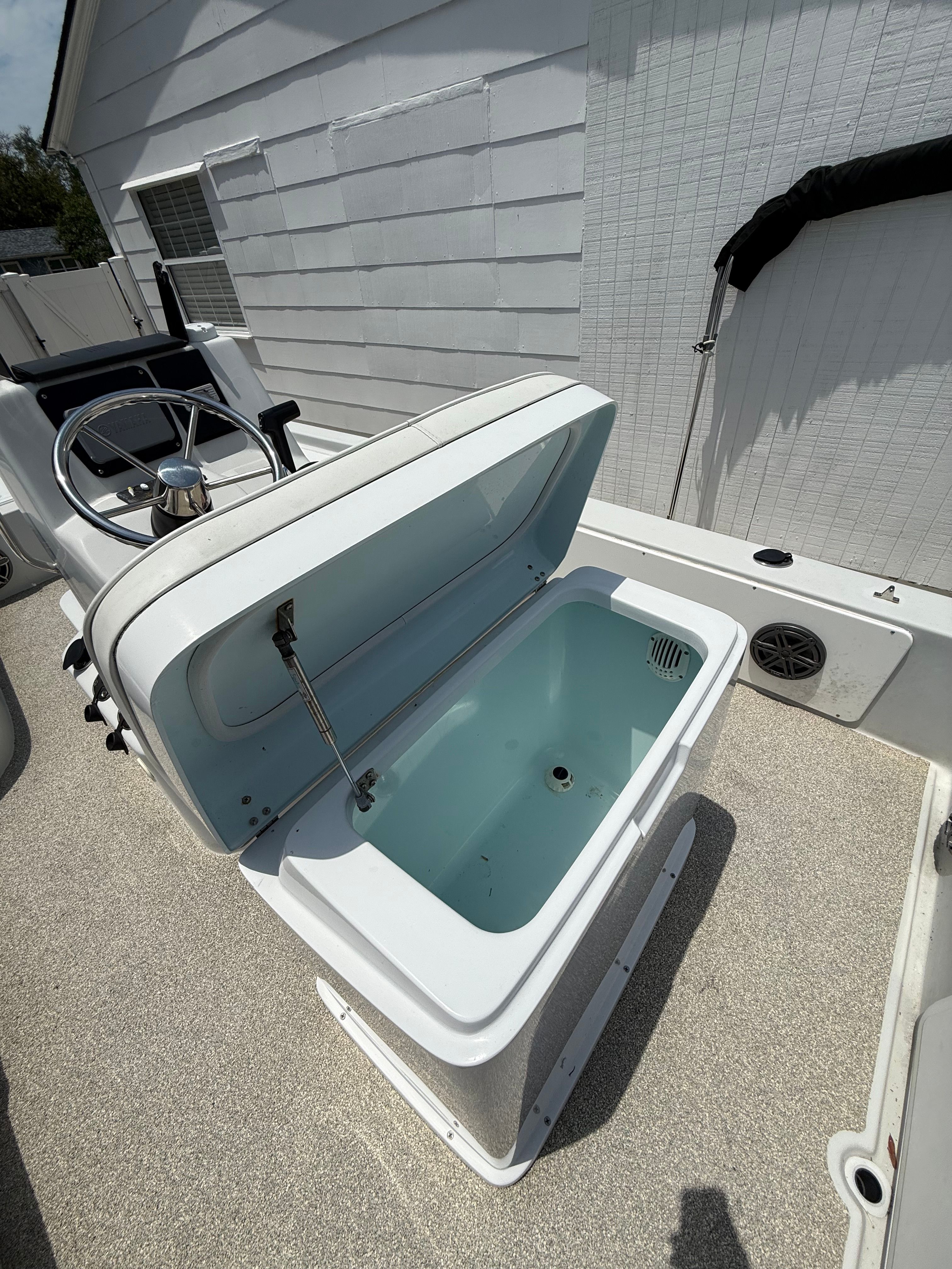 2012 Bay Craft 21 boat with open storage compartment lid.